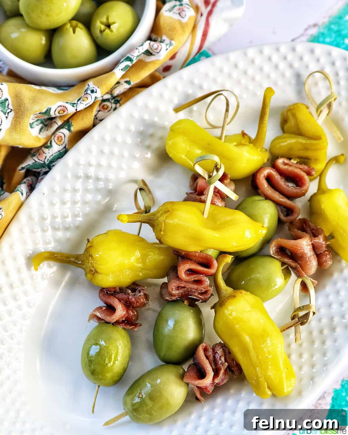 Gilda A Basque Classic 3 Gilda pintxos: food sticks with peppers, anchovies, and olives on a white plate, symbolizing a classic Spanish tapa.