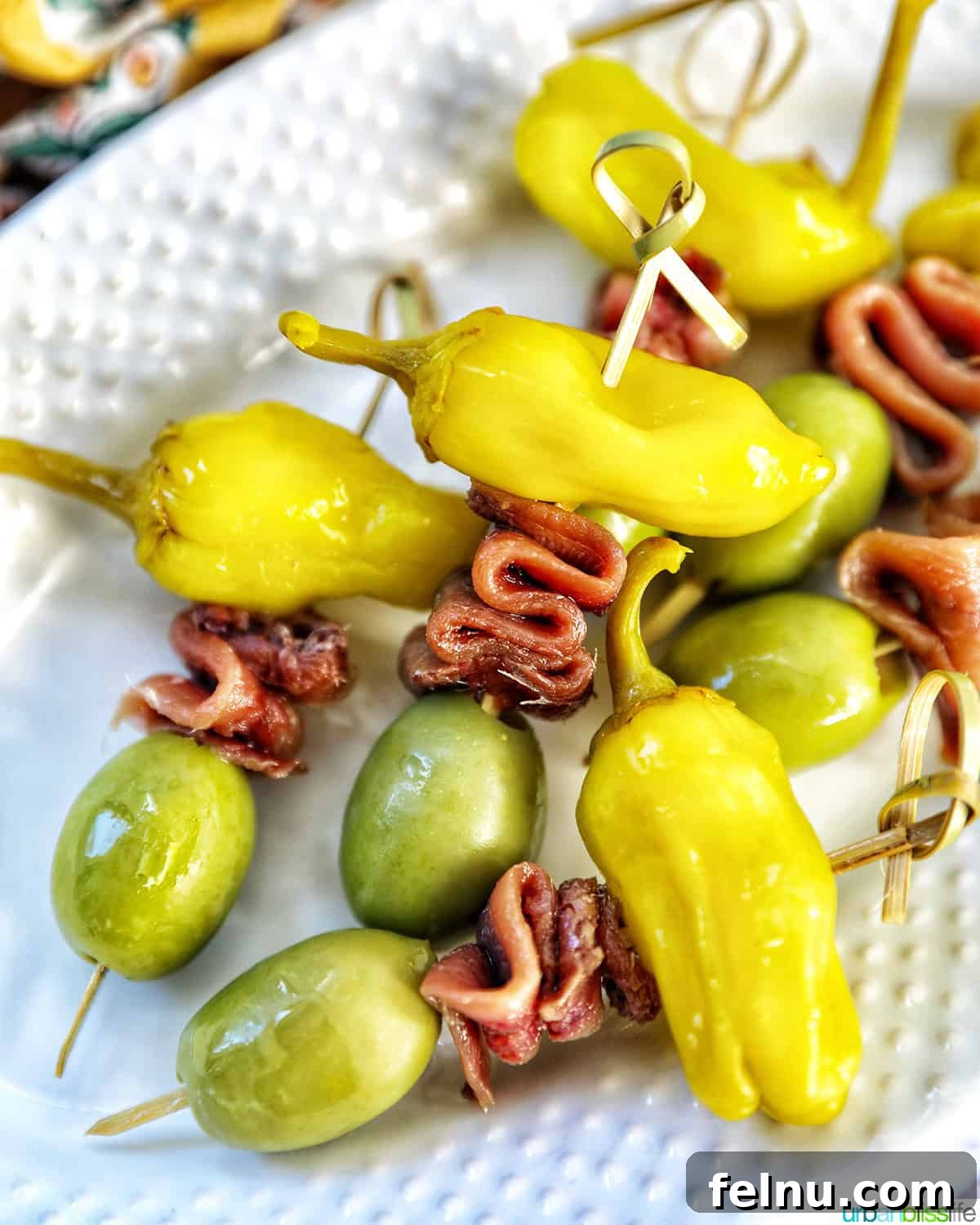 Gilda A Basque Classic 9 A close-up of Gilda pintxos, featuring the pepper, anchovy, and olive clearly visible on a white plate, highlighting their appetizing simplicity.