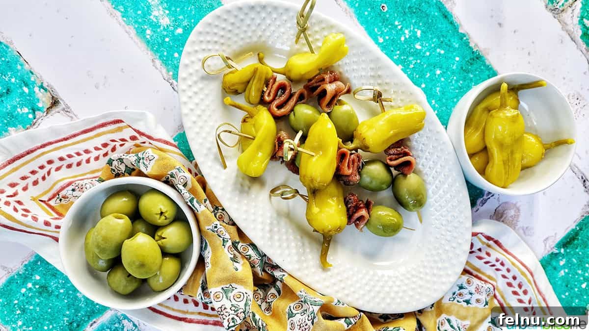 Gilda A Basque Classic 10 A plate of Gilda pintxos elegantly arranged, with small bowls of olives and peppers nearby, showcasing an ideal appetizer setup.