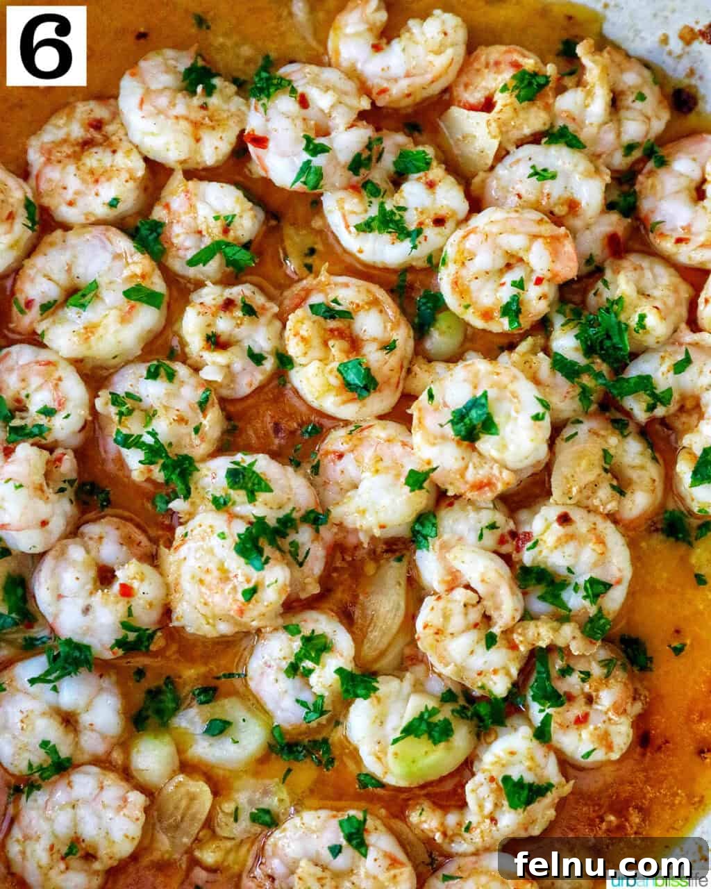 Savory Shrimp Bites 11 gambas al ajillo in a pan garnished with fresh parsley.
