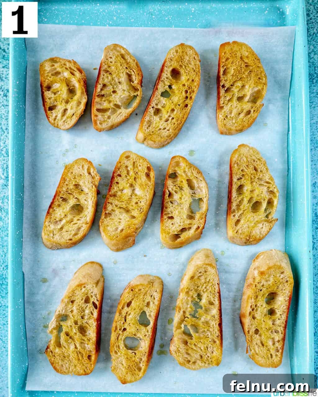 Savory Shrimp Bites 5 sliced baguette on a parchment paper-lined baking sheet.