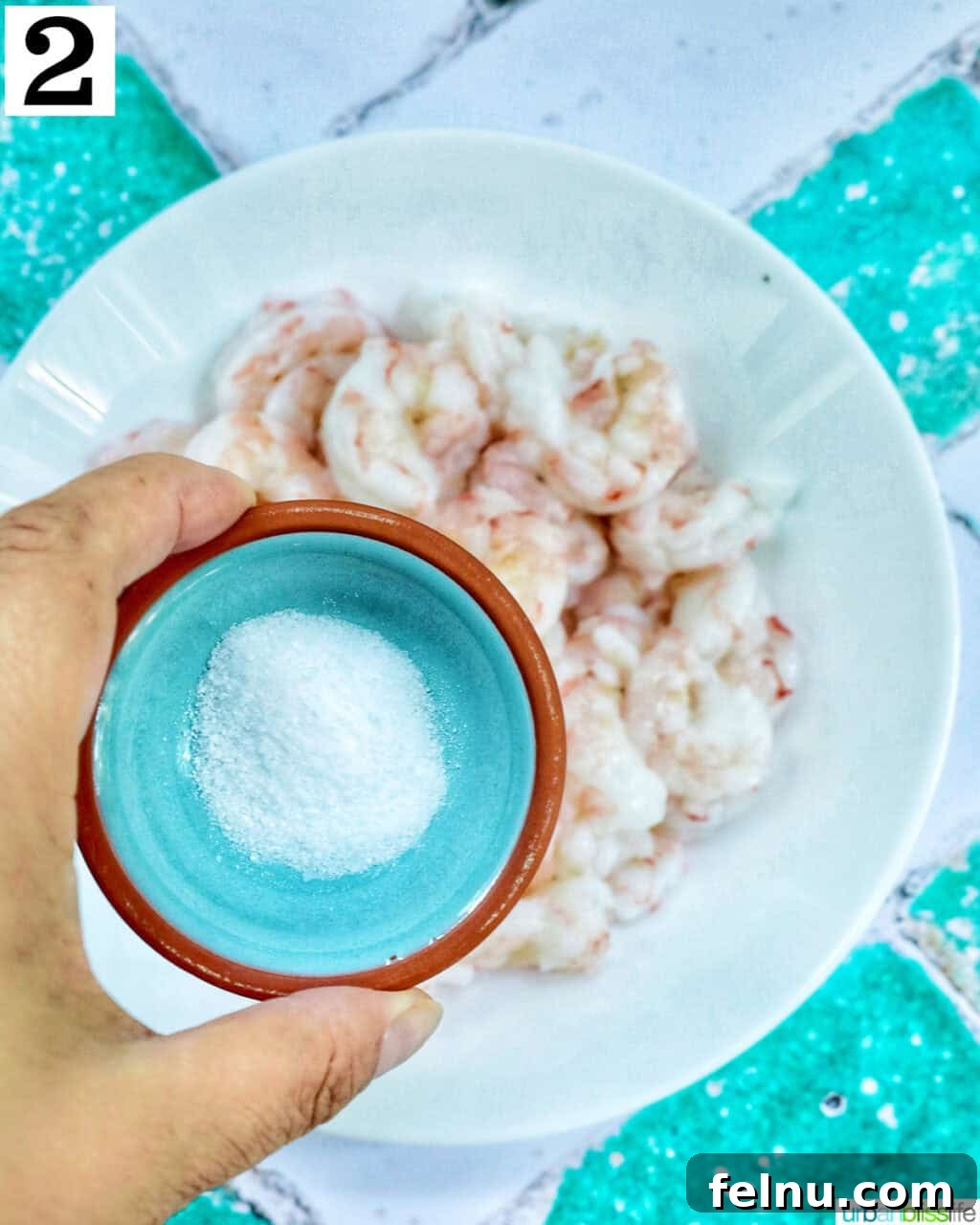 Savory Shrimp Bites 6 hand holding a small bowl of salt over a bowl of shrimp.