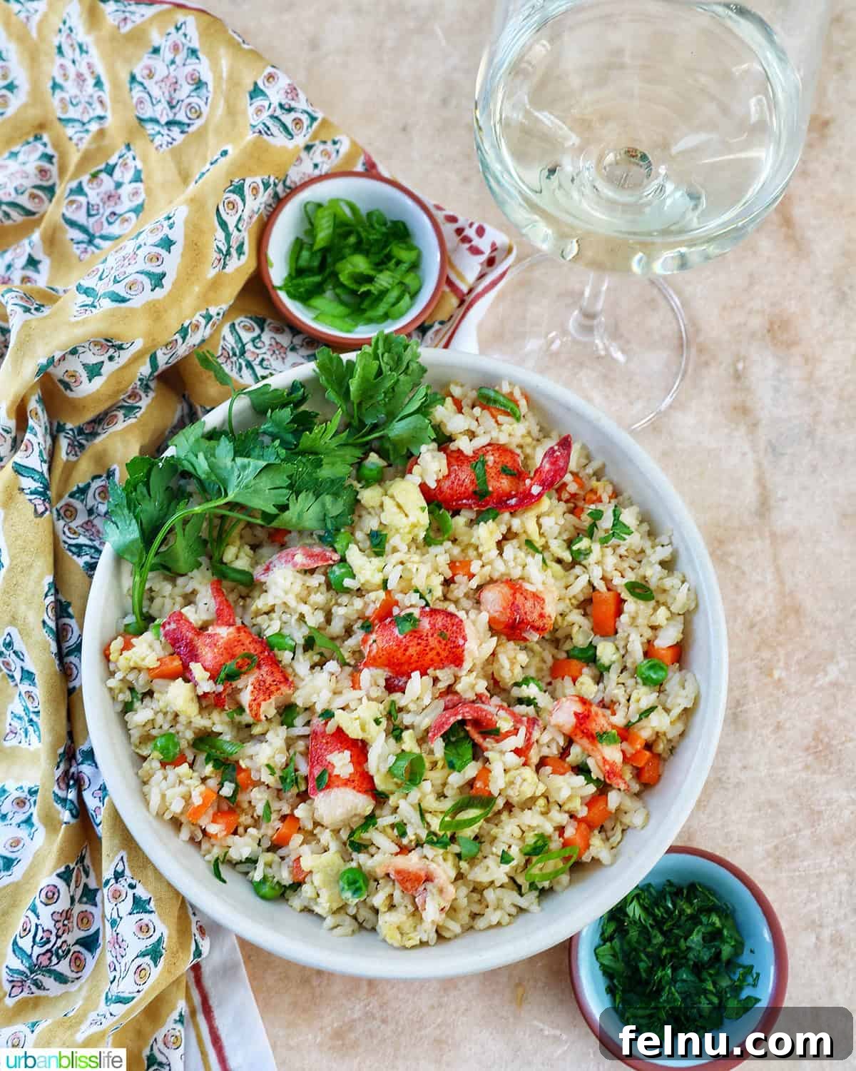 Decadent Lobster Fried Rice 15 bowl of lobster fried rice with bowls of fresh herbs and a glass of white wine.