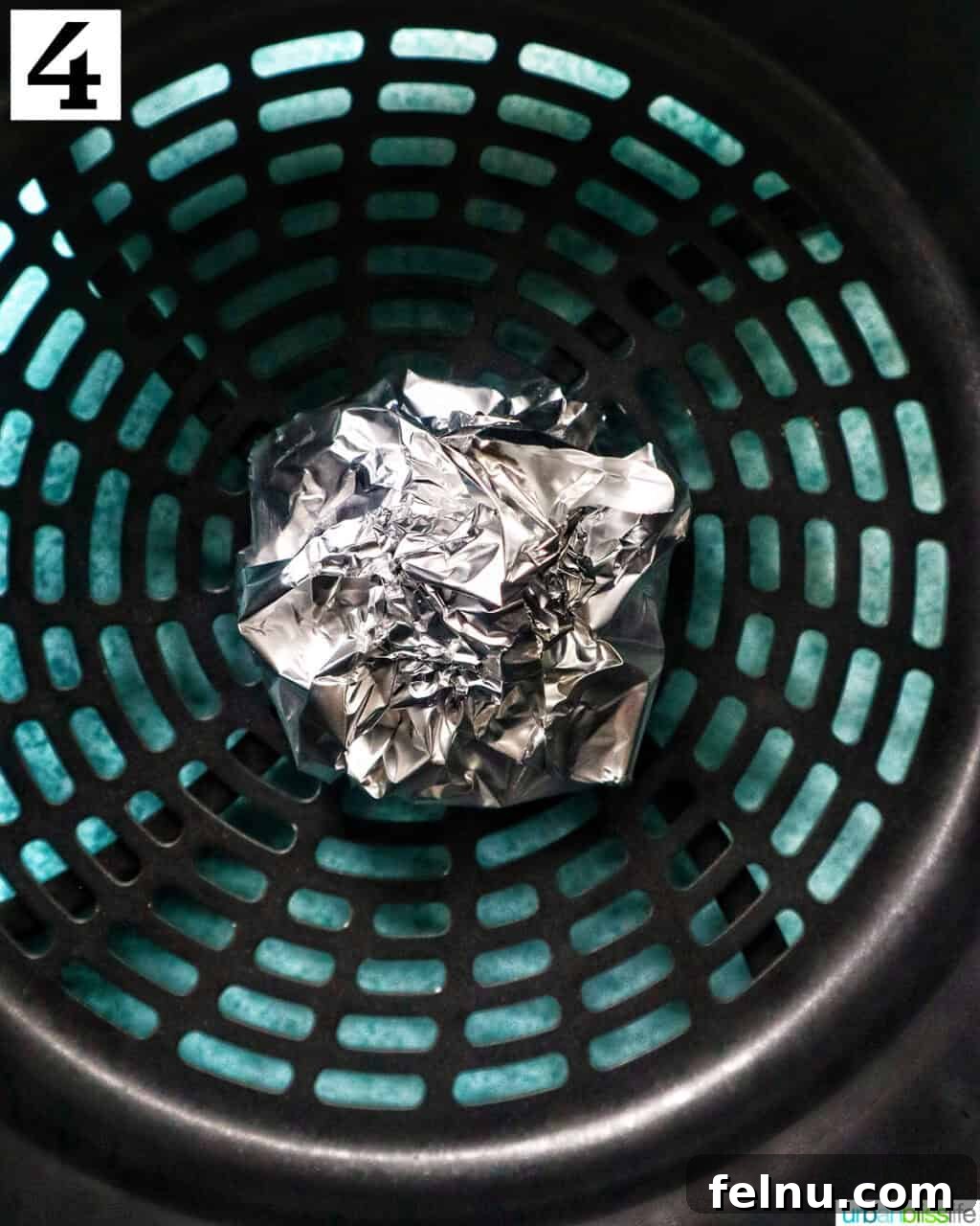 Golden Butternut Squash and Roasted Garlic Spread 8 aluminum foil pack of garlic head in an air fryer basket.