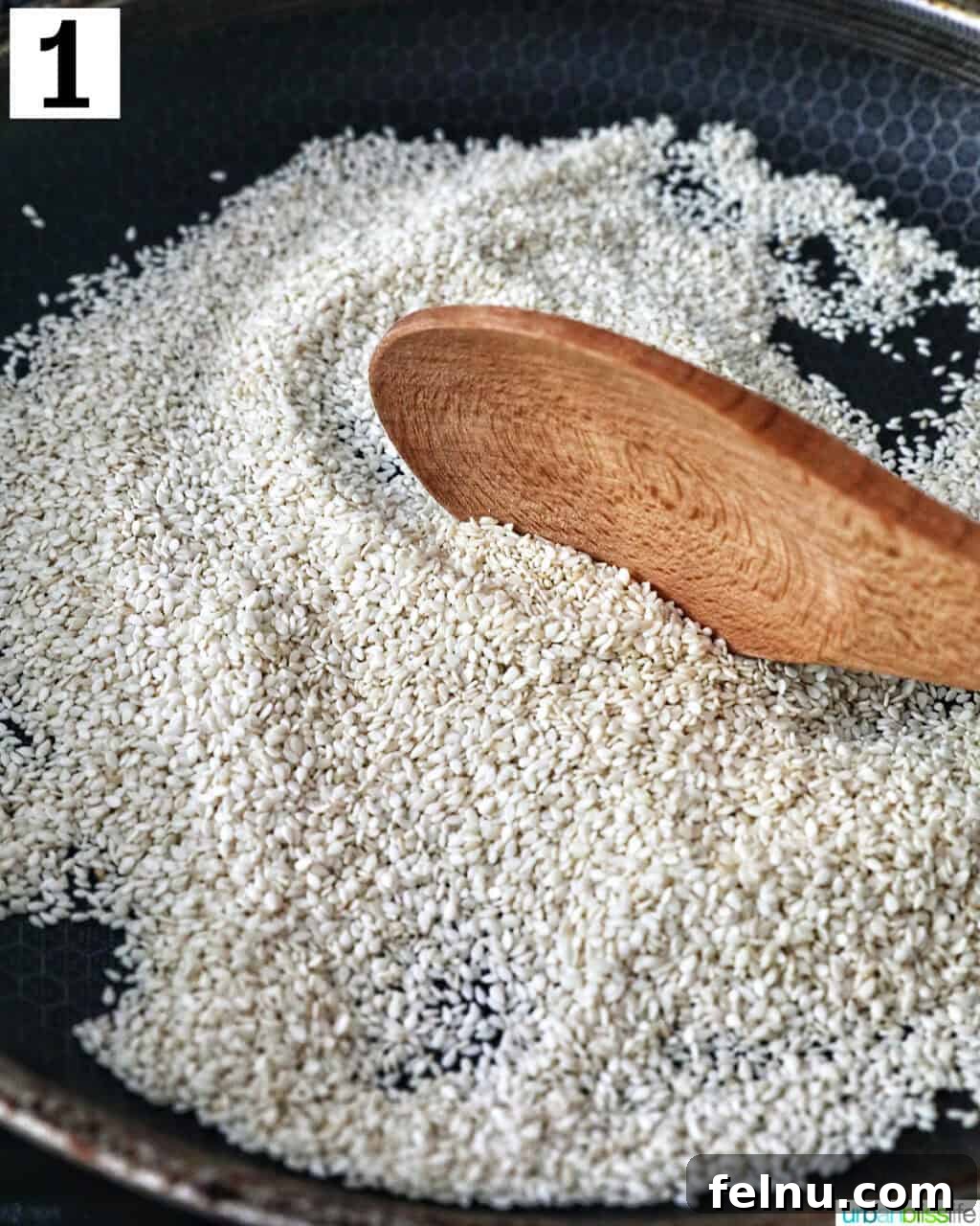 Crafting Your Own Tahini 6 wooden spoon with sesame seeds toasting in a pan.