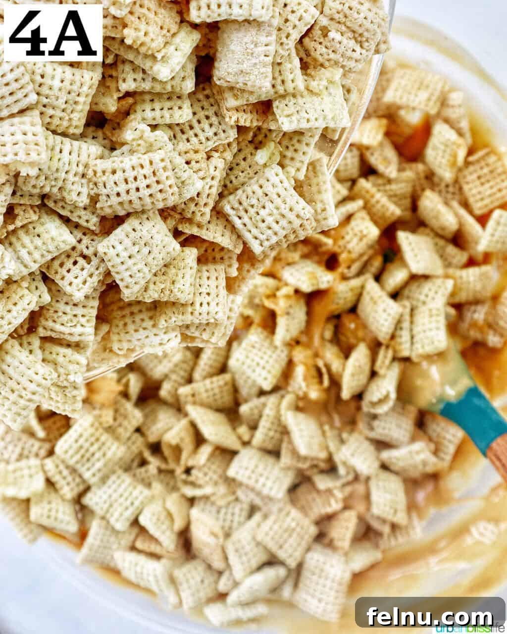 Effortlessly Delicious Patriotic Puppy Chow 8 Gently mixing rice Chex cereal with the patriotic puppy chow coating in a large bowl.