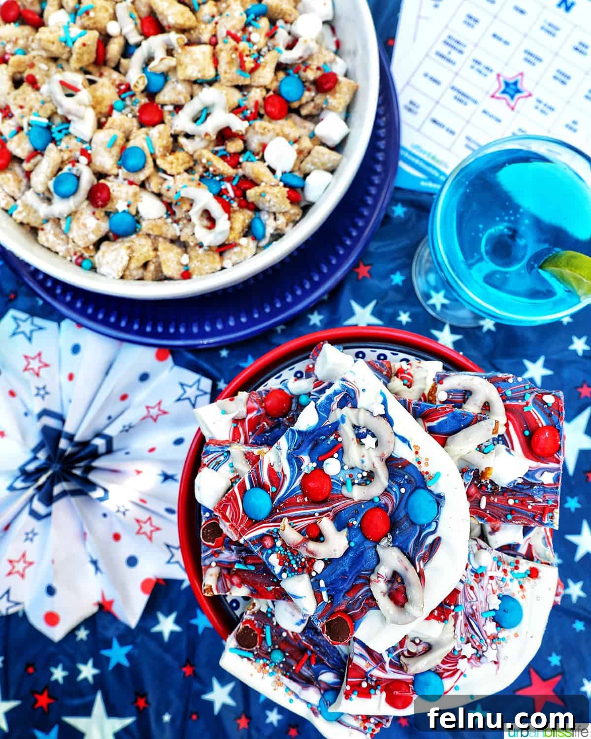 Fourth of July Freedom Bark 16 A festive spread featuring a bowl of red, white, and blue bark, alongside patriotic puppy chow and a refreshing blue wave cocktail.