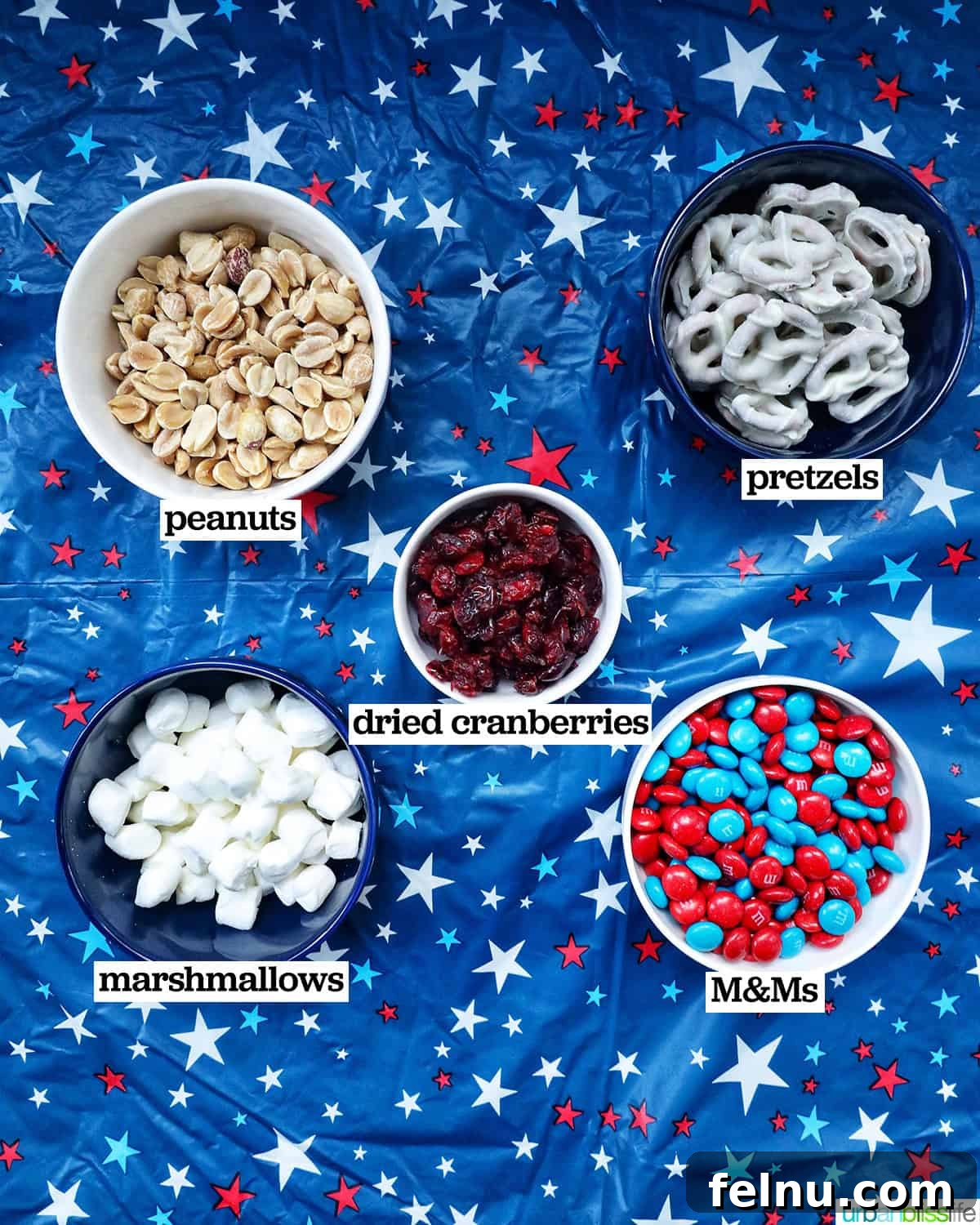 Stars and Stripes Snack Blend 4 Bowls filled with individual ingredients laid out for making red, white, and blue trail mix.
