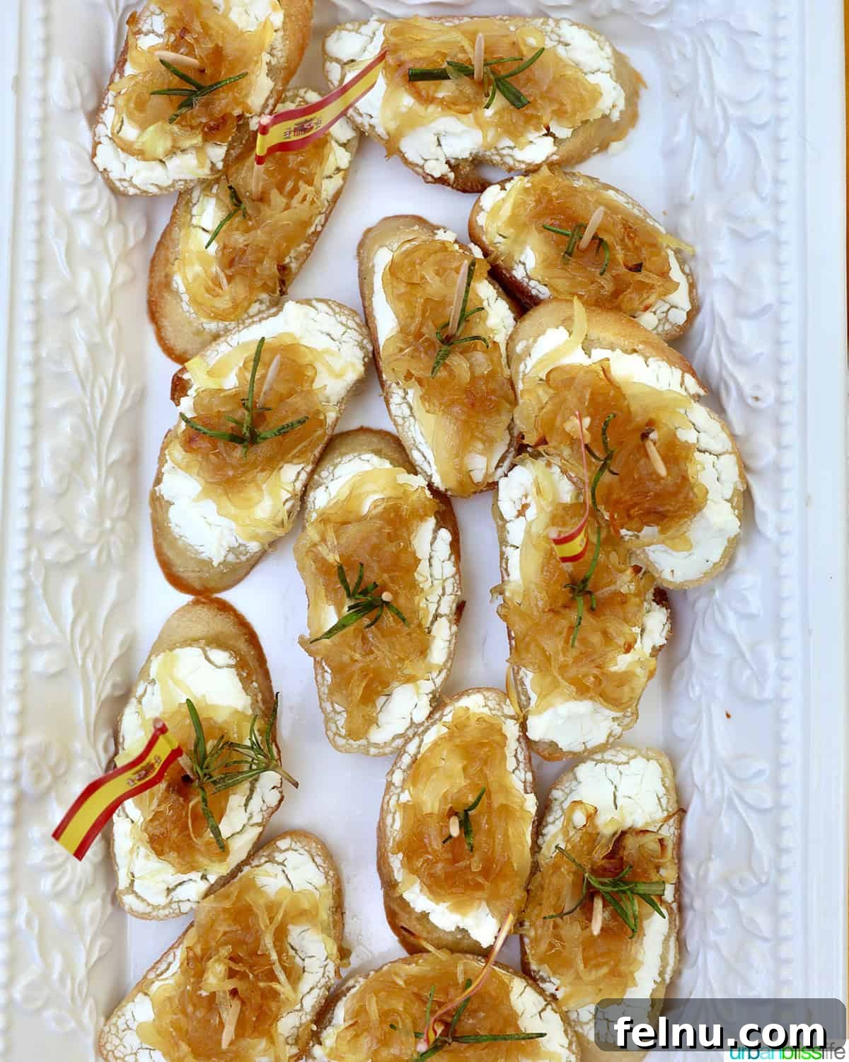 Golden Onion and Chevre Morsels 12 Overhead shot of a platter of caramelized onion and goat cheese crostini, artfully arranged and garnished with rosemary.