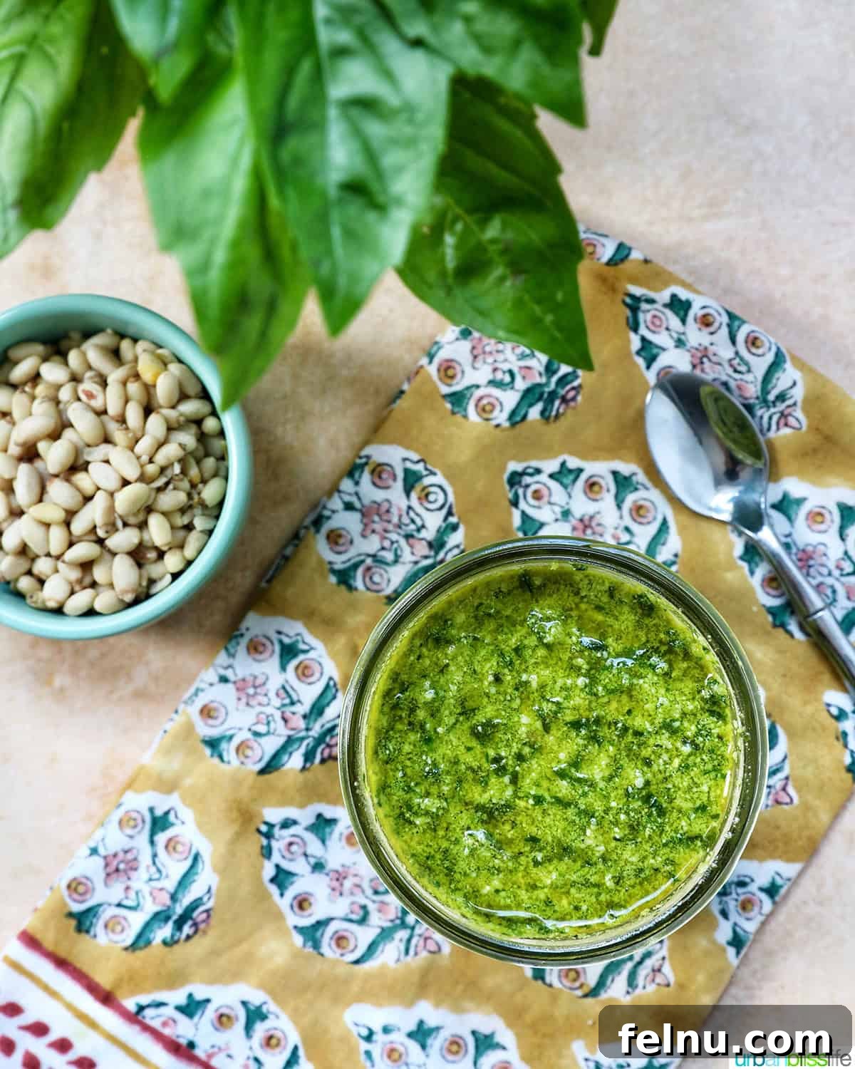 Homemade Basil Pesto: A Burst of Summer Flavor 8 Pesto in a mason jar next to a bowl of pine nuts and basil leaves