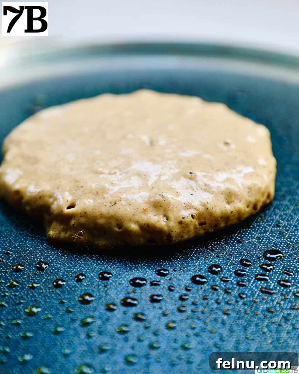 Pumpkin spice pancake cooking on a hot griddle.