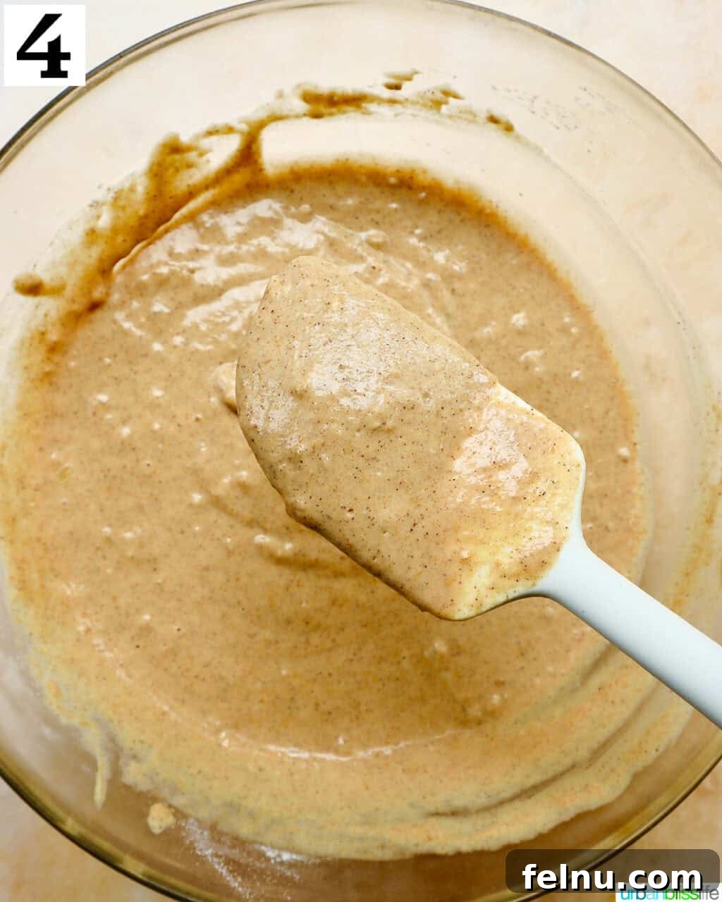 Mixing pancake batter with a spatula, ensuring not to overmix.