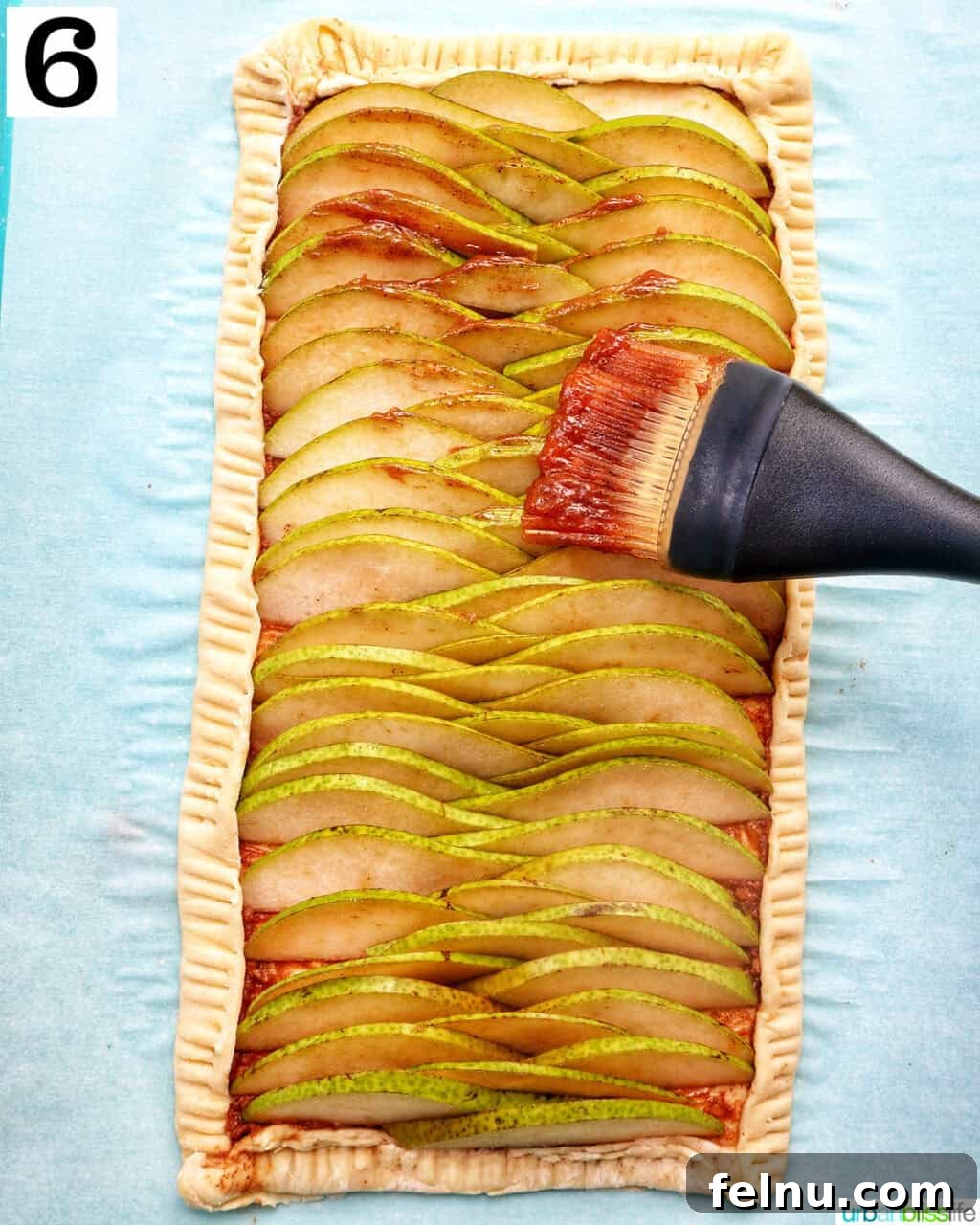 Image showing the remaining butter mixture being brushed over the pears and folded dough.