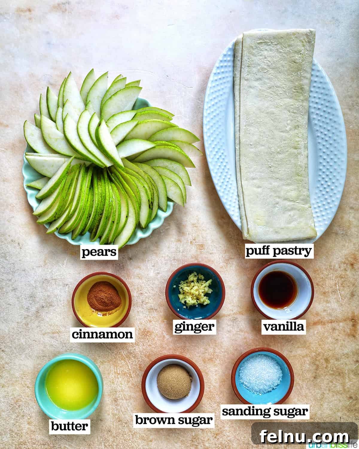 A curated arrangement of ingredients needed to make Ginger and Pear Tart with Puff Pastry, including pears, ginger, brown sugar, and spices.