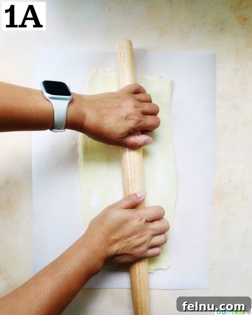Image showing the puff pastry being rolled out on a floured surface into a rectangle.