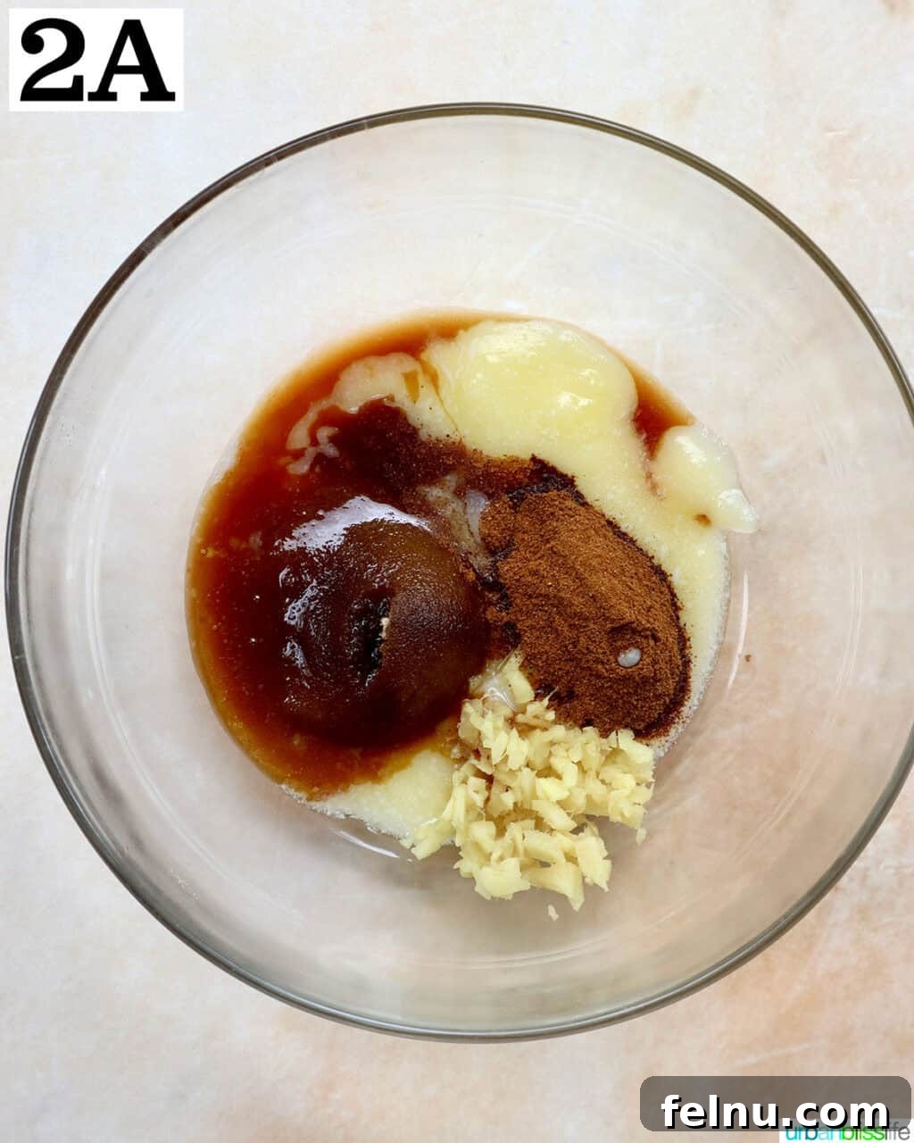 Image showing the melted butter, brown sugar, ginger, vanilla, and cinnamon mixture being mixed in a bowl.