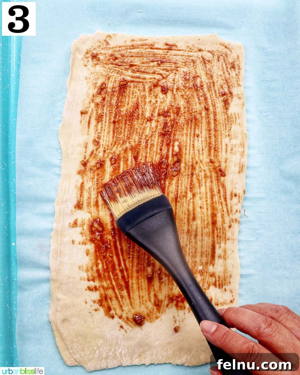 Image showing the puff pastry with the butter mixture spread on top.