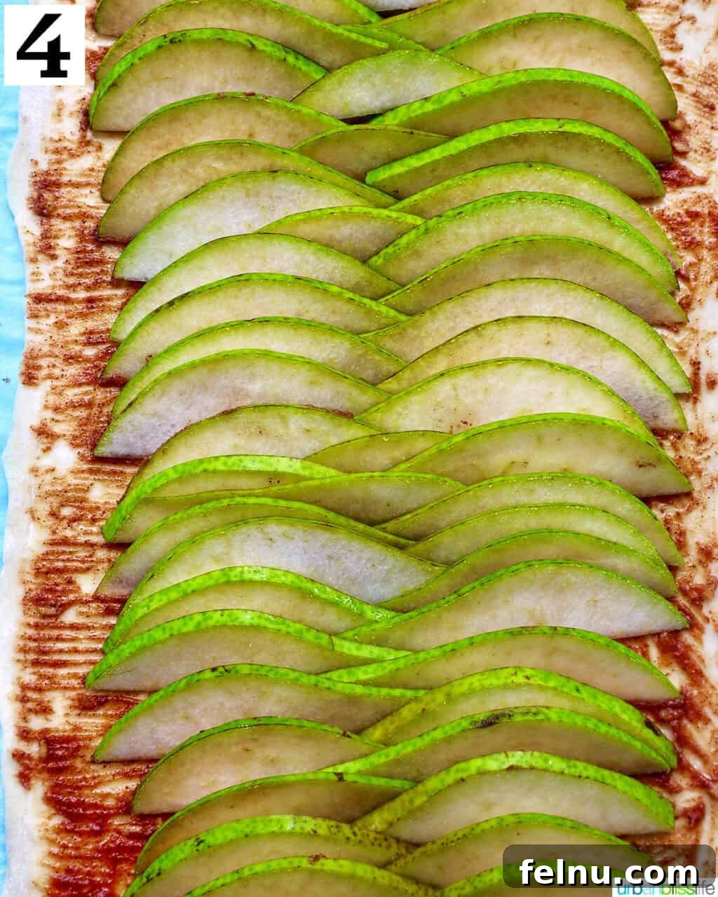 Image showing the sliced pears being layered evenly onto the puff pastry.