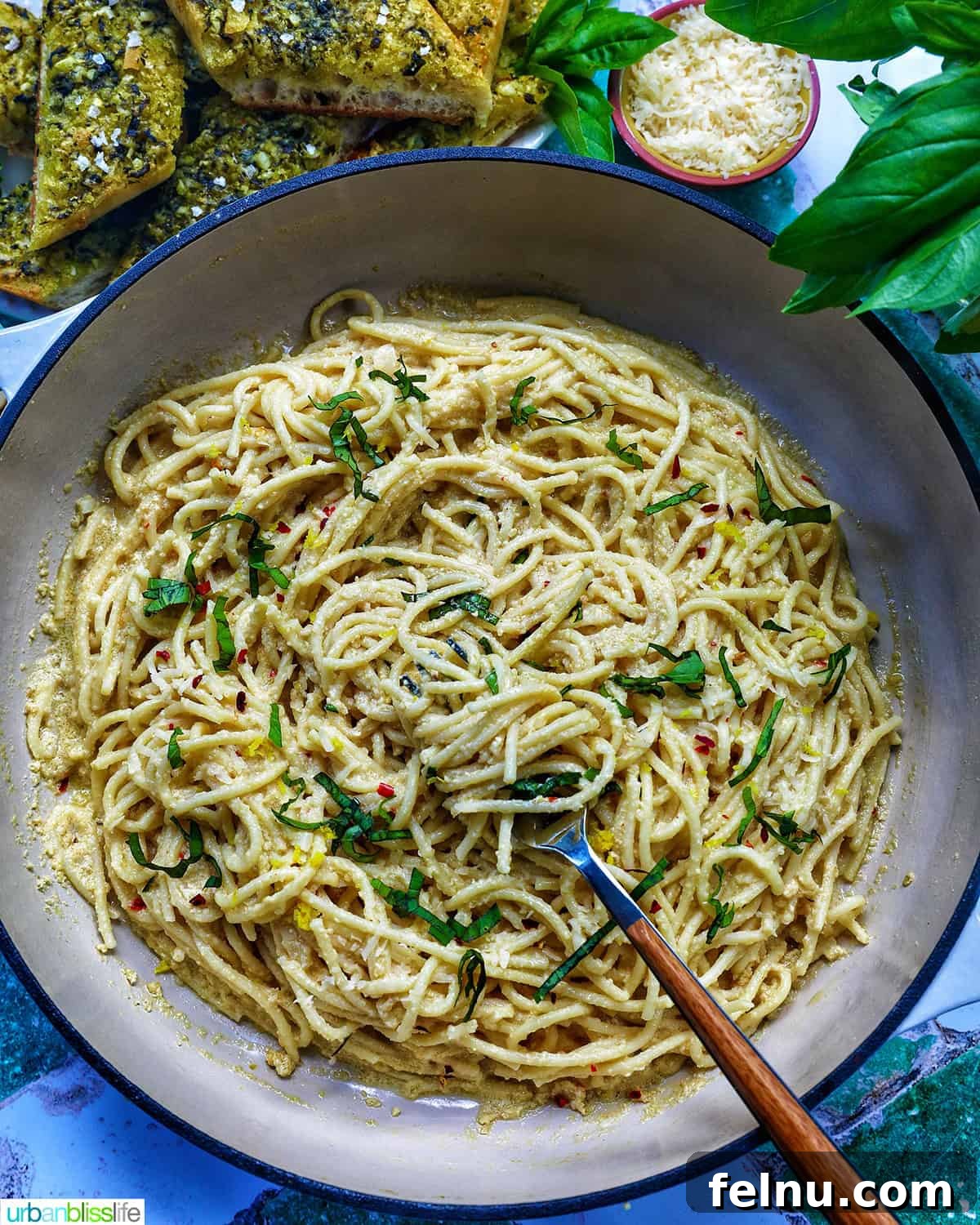 Tahini Sweet Treat 14 Saucepan of tahini pasta with pesto bread and side bowls of garnishes.