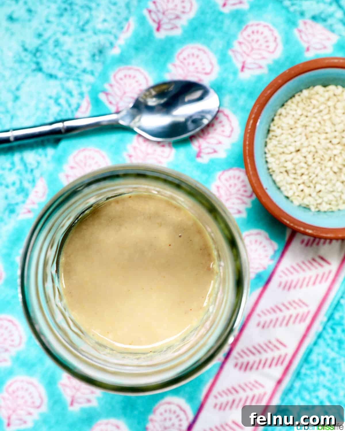 Tahini Sweet Treat 3 Jar of homemade tahini with sesame seeds and a spoon.