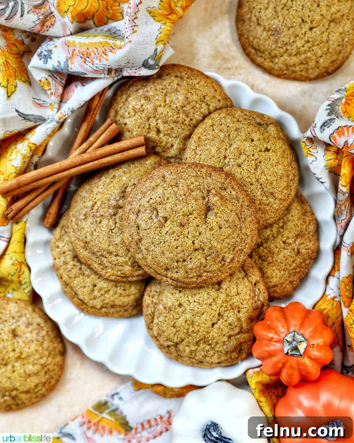 plate full of pumpkin spice cookies with pumpkin decorations and cinnamon sticks.