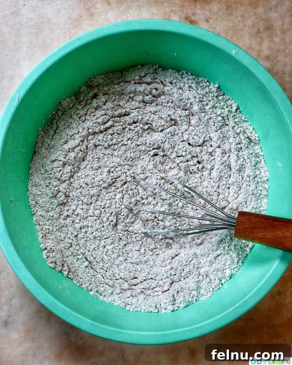 dry ingredients to make pumpkin spice cookies in a green bowl.