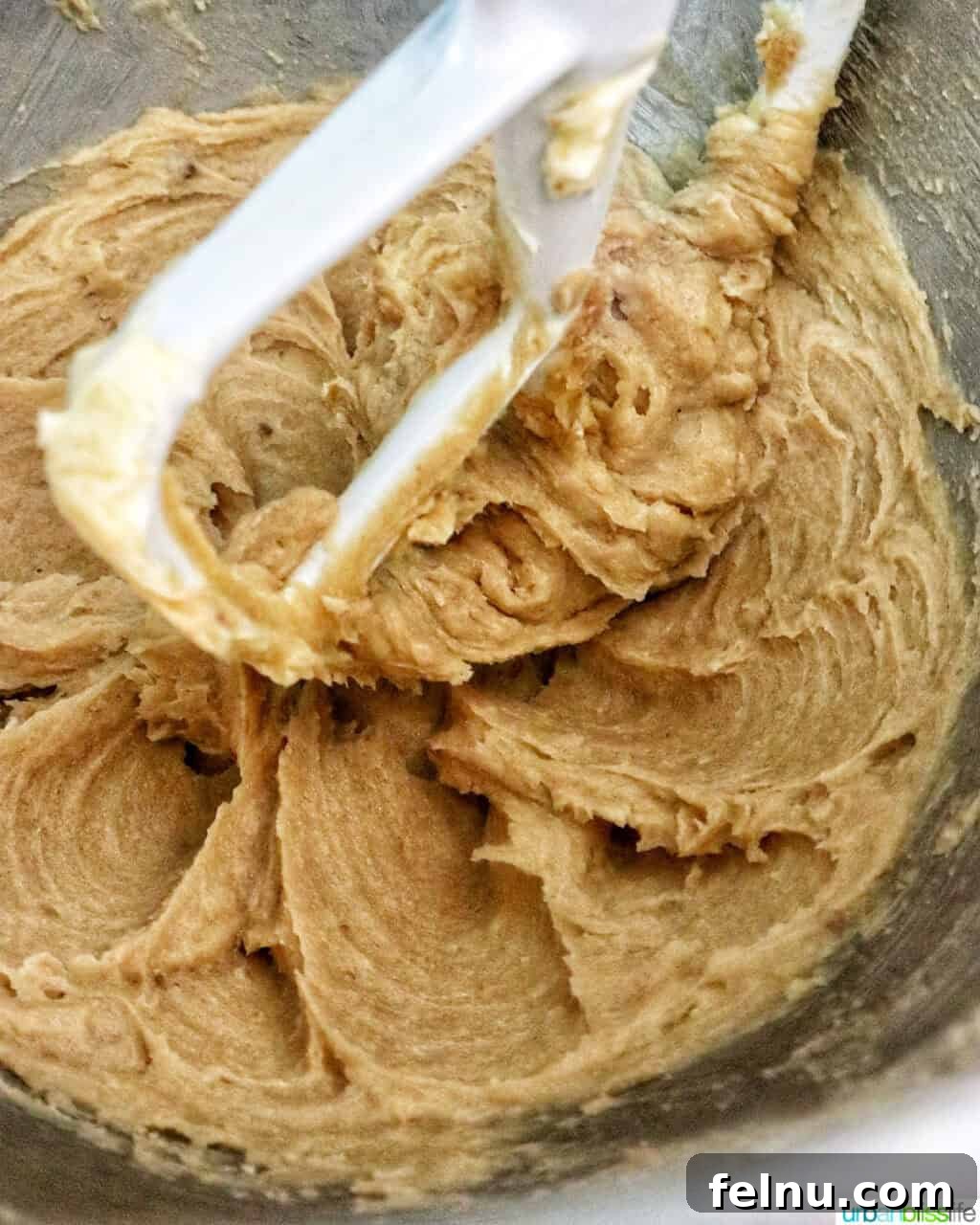 pumpkin pie spice batter in a stand mixer bowl.