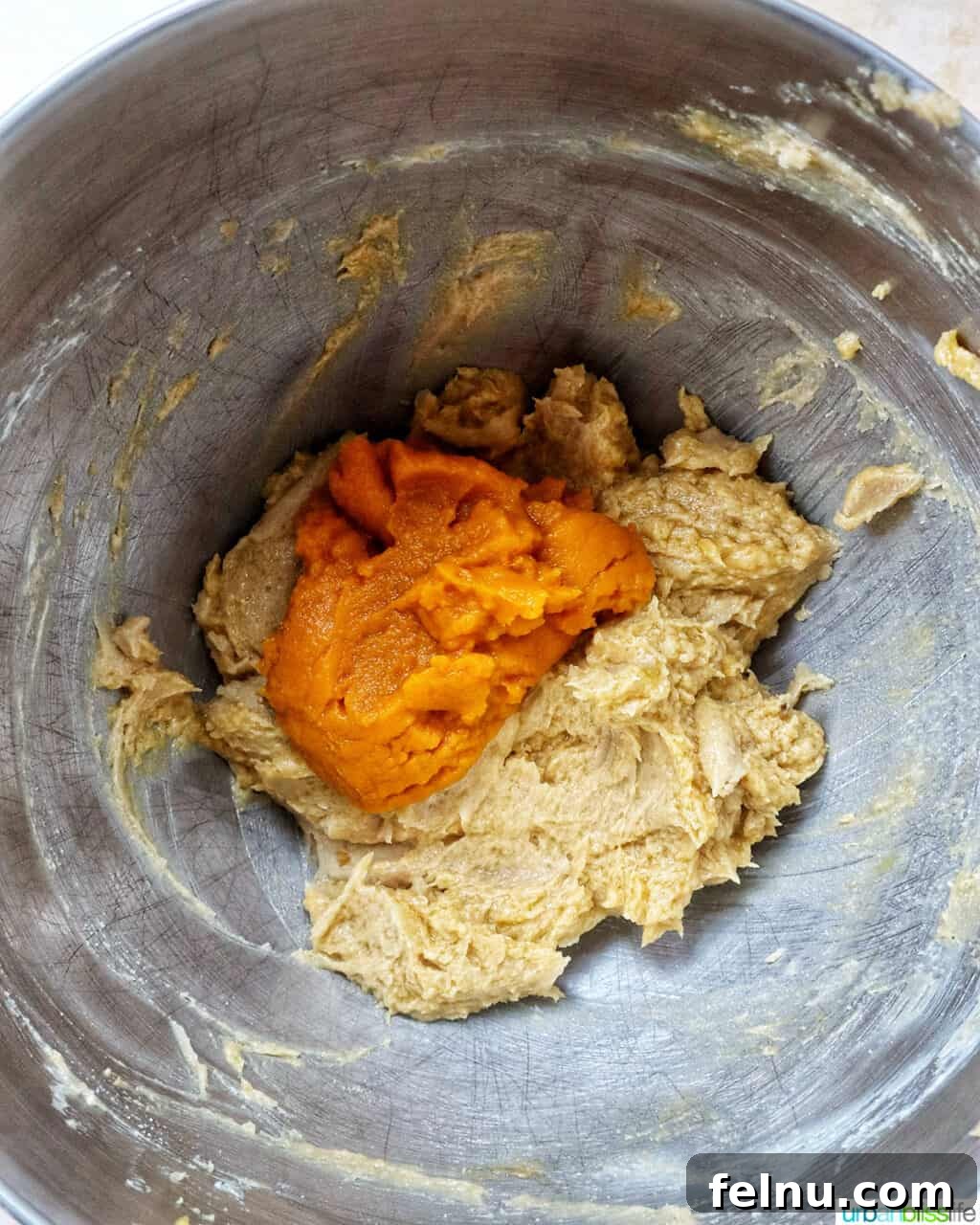 pumpkin pie spice batter in a stand mixer bowl.