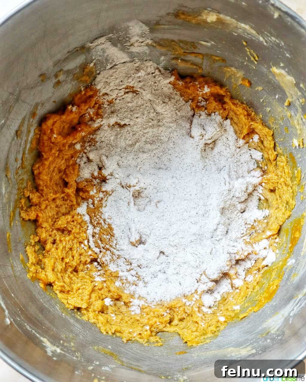 pumpkin pie spice batter in a stand mixer bowl.