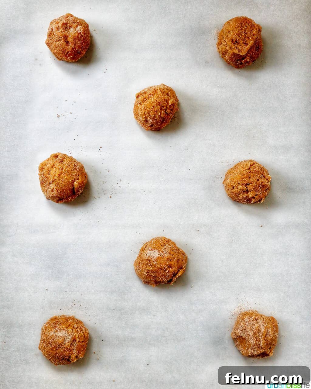 pumpkin pie spice cookie dough balls on a baking sheet.
