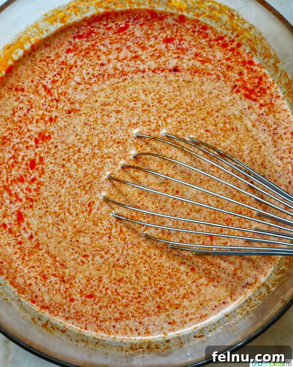 Slow Cooker Massaman Beef Curry 7 Whisking together the curry sauce ingredients in a large bowl, combining the curry paste, coconut cream, and spices for the slow cooker beef massaman curry recipe.