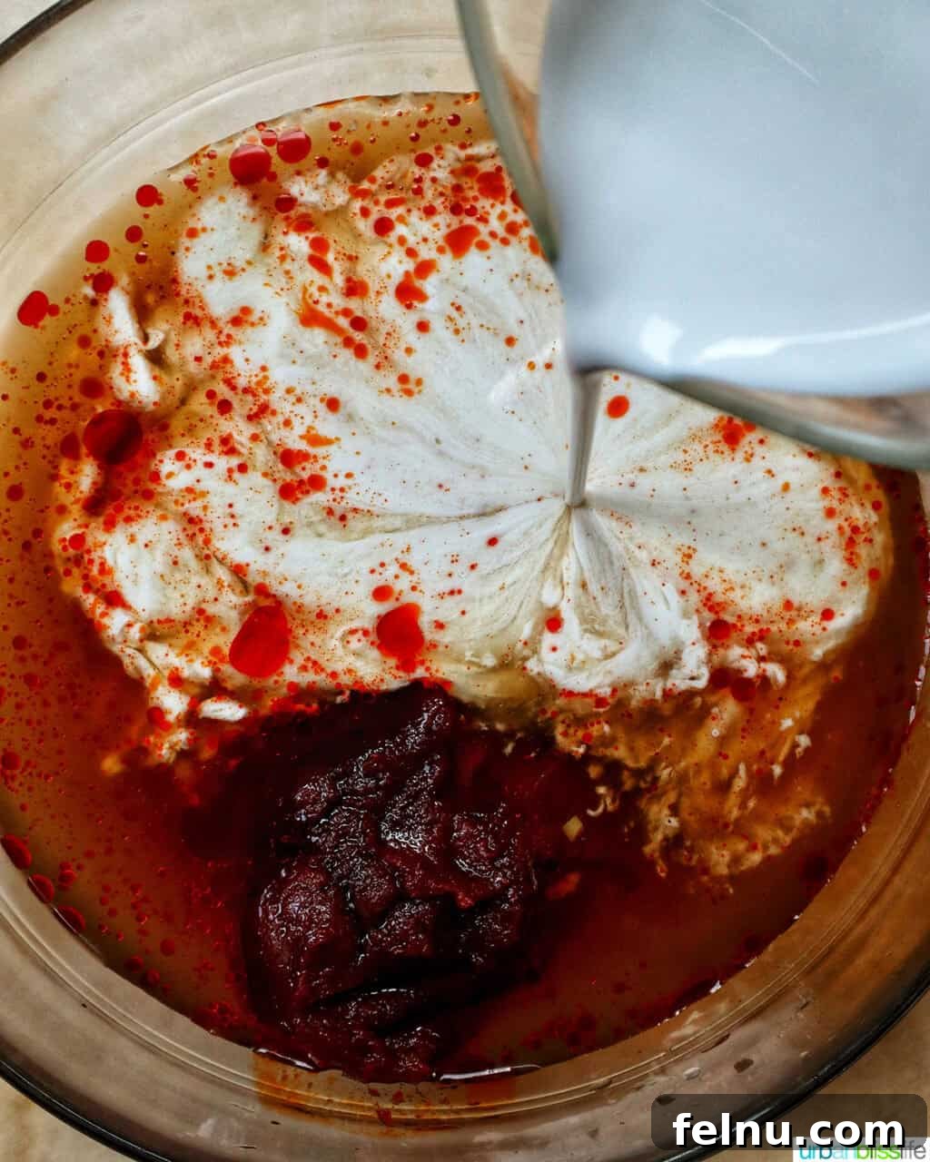 Slow Cooker Massaman Beef Curry 8 Pouring coconut cream into the curry sauce mixture, enriching the flavors for the slow cooker beef massaman curry recipe.