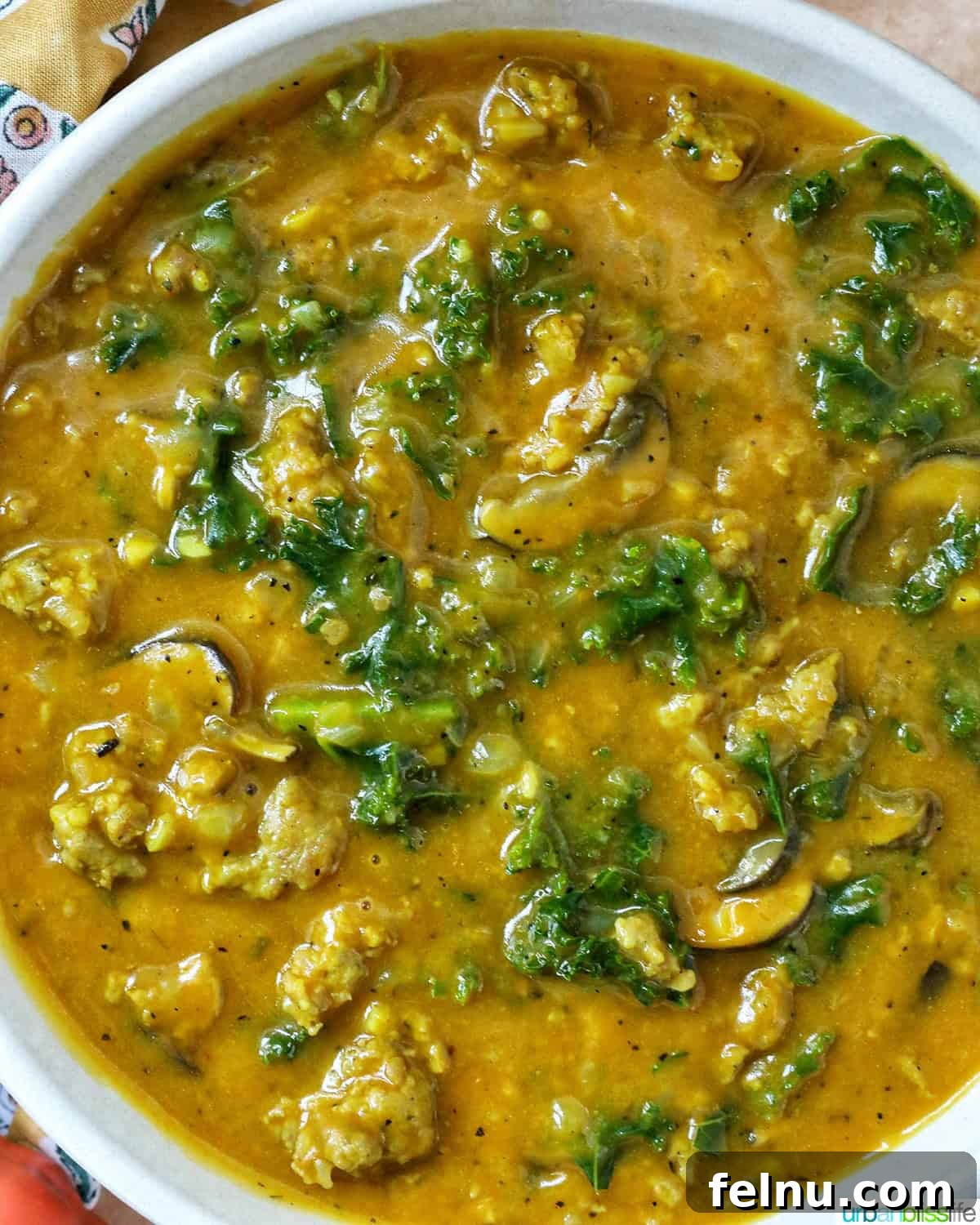 Smoky Sausage Pumpkin Bisque 15 A delicious bowl of pumpkin soup with sausage, presented closely to emphasize its rich texture and inviting warmth.