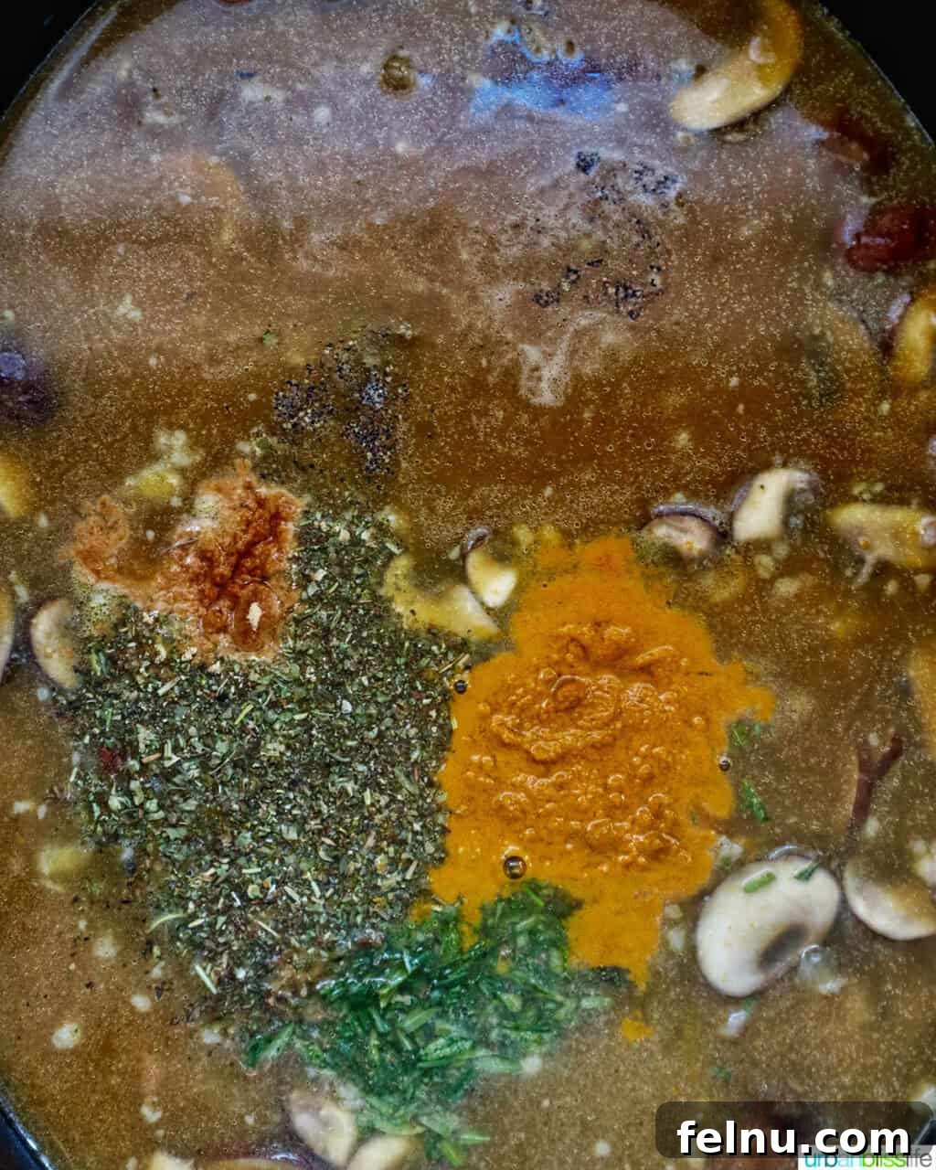 Smoky Sausage Pumpkin Bisque 8 A blend of vibrant spices and aromatic herbs being carefully added to the simmering pumpkin sausage soup in a Dutch oven, infusing it with flavor.