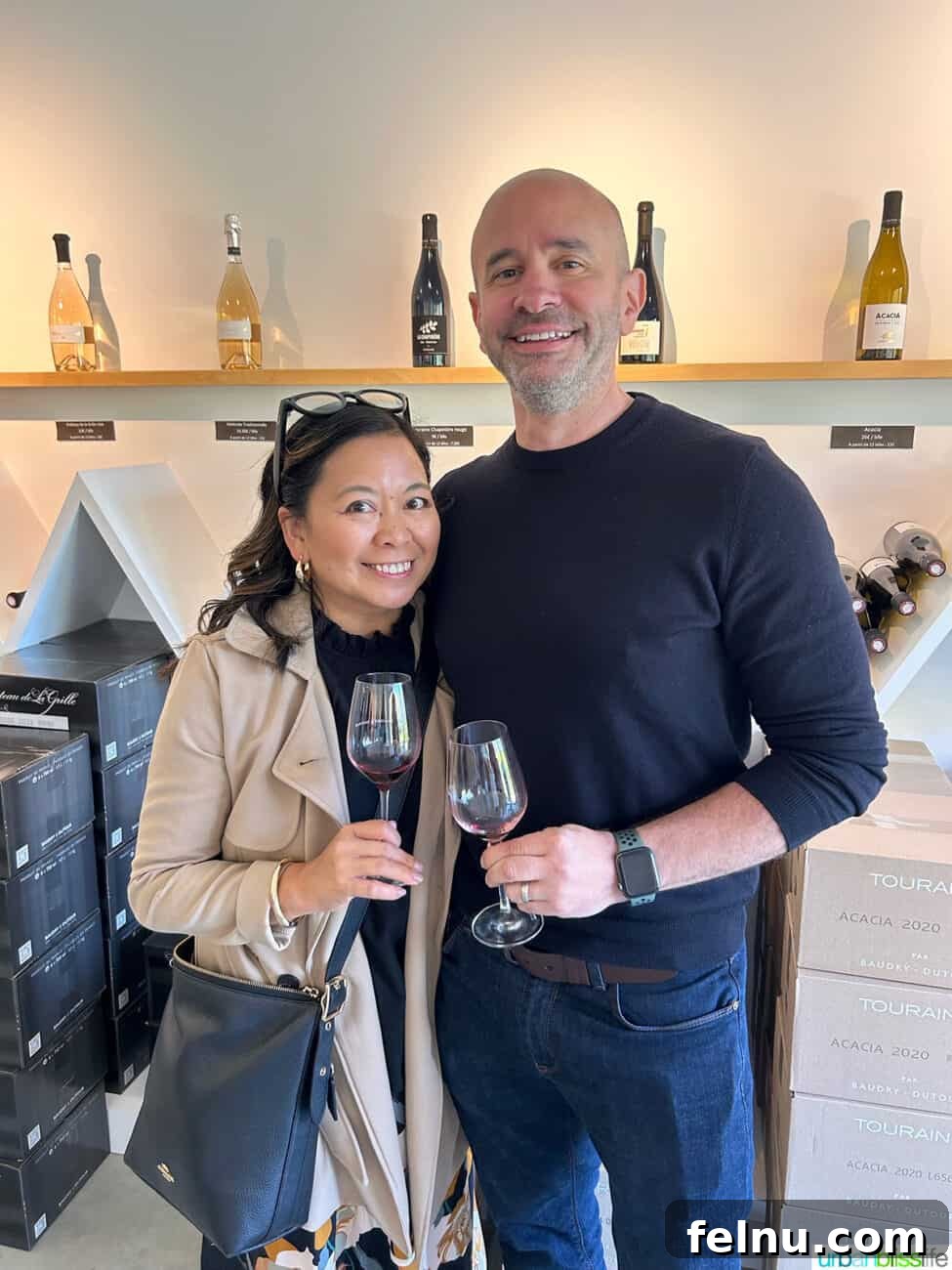Uncorking the Elegance of Chateau de la Grille 10 Marlynn Jayme Schotland and Alain Schotland sharing a joyful moment, holding wine glasses in the elegant wine tasting room at Château de la Grille in Chinon, France.