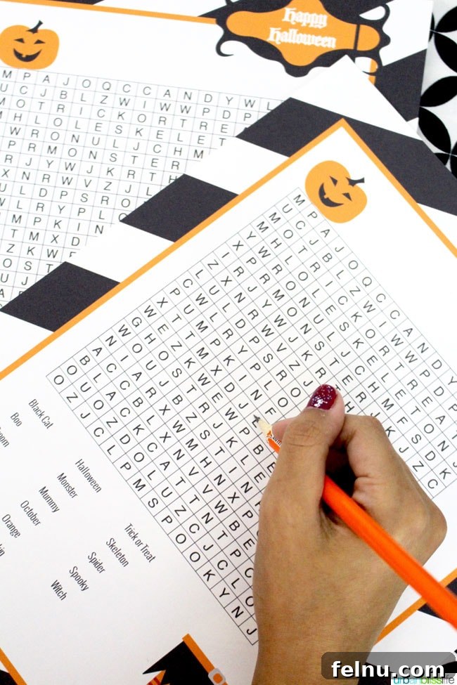 Spooky Season Essentials: Free Halloween Printables 8 hand with pencil doing a Halloween Word Search
