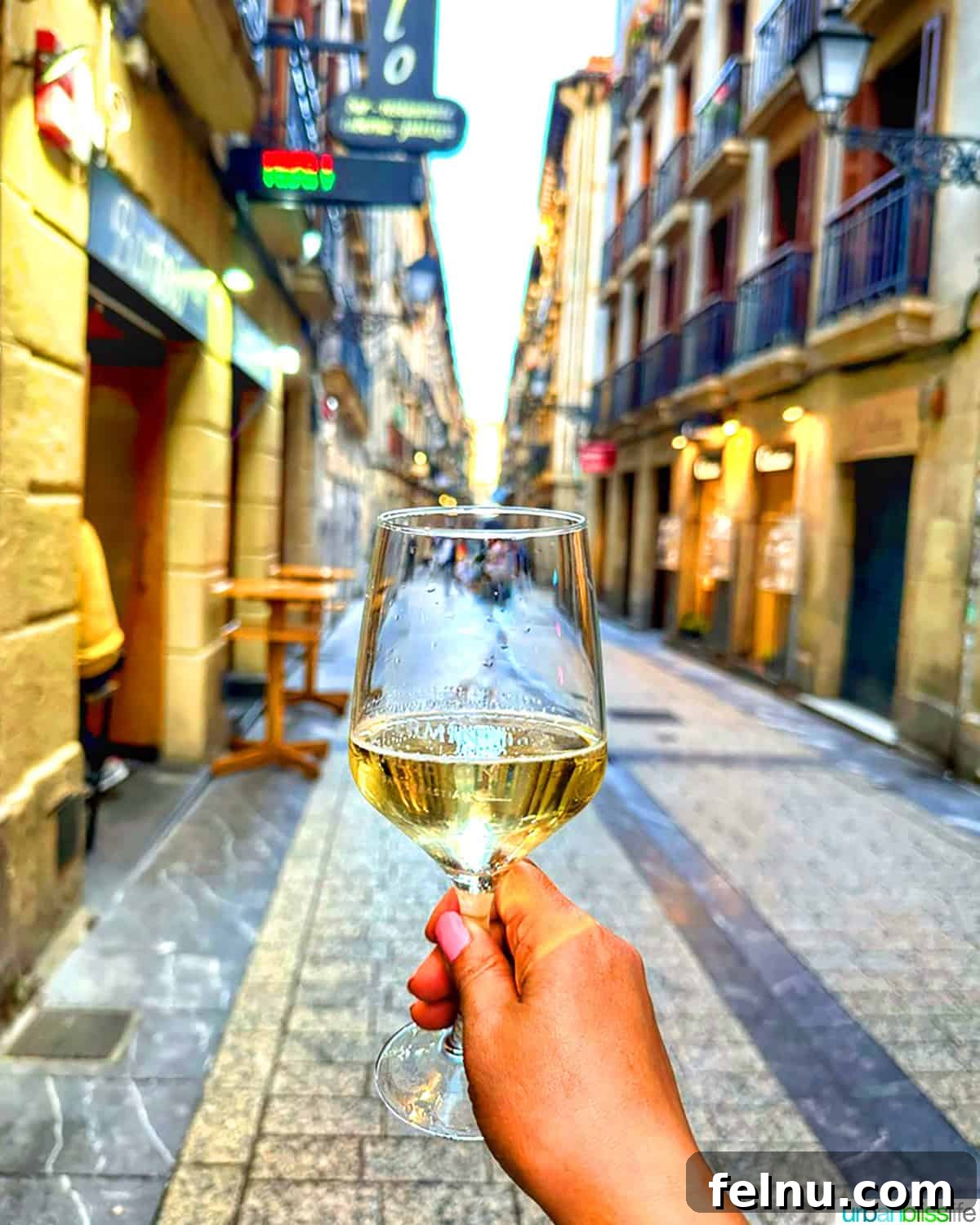 Txakoli Wine Explained: Basque Country's Unique Sip 2 holding glass of txakoli wine in old town san sebastian, spain