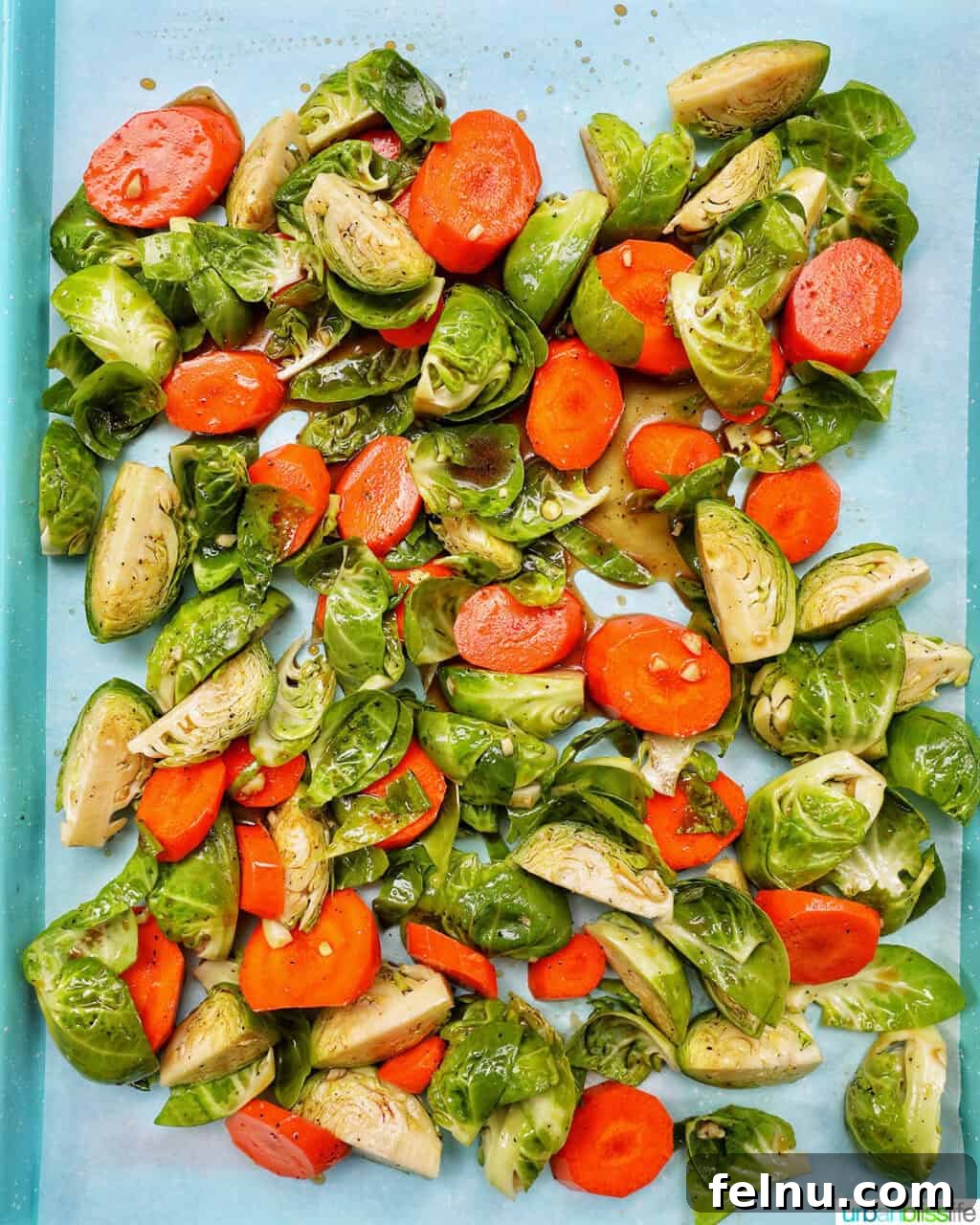 Roasted Brussels Sprouts with Maple-Glazed Carrots 7 Roasted Brussels sprouts and carrot slices spread out on a baking sheet.