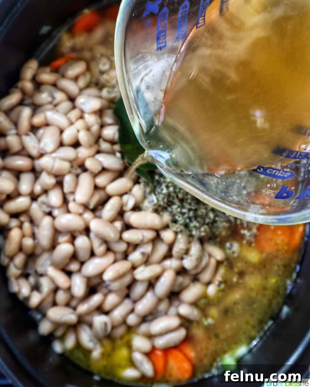 Tuscan Kale and White Bean Soup: A Hearty Italian Classic 10 Pouring vegetable broth into the soup