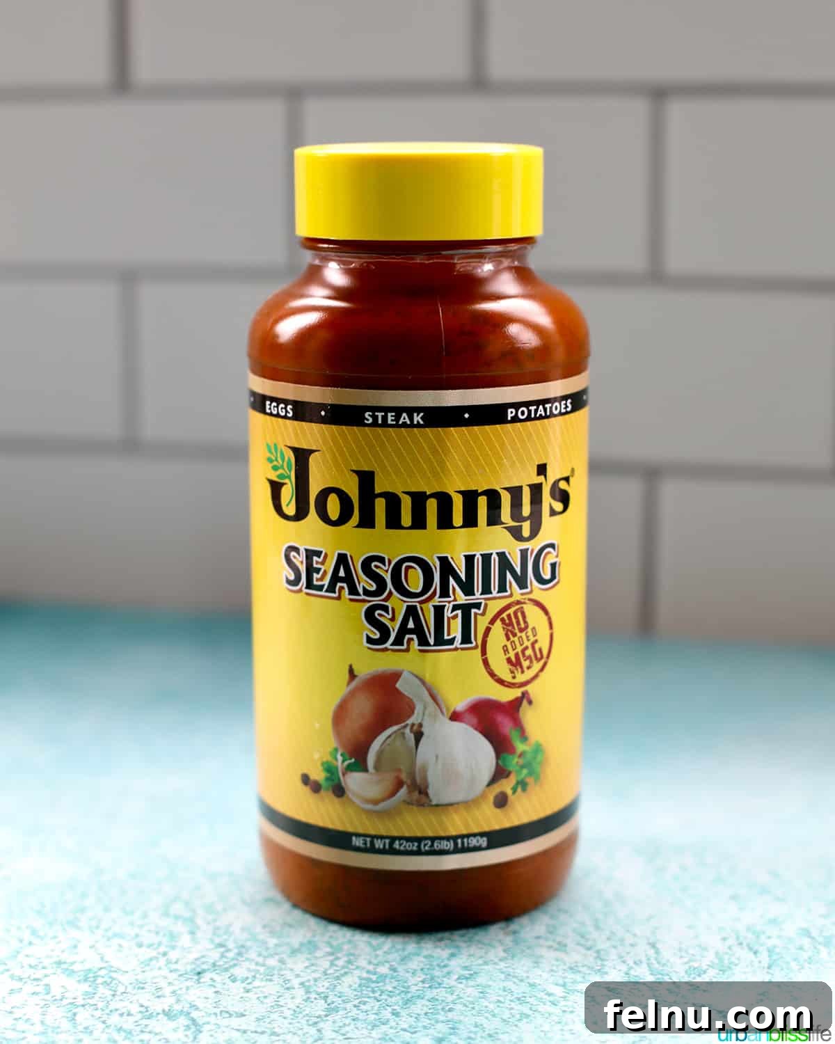 A jar of Johnny's Seasoning Salt, a key ingredient for authentic Filipino Lumpia flavor.