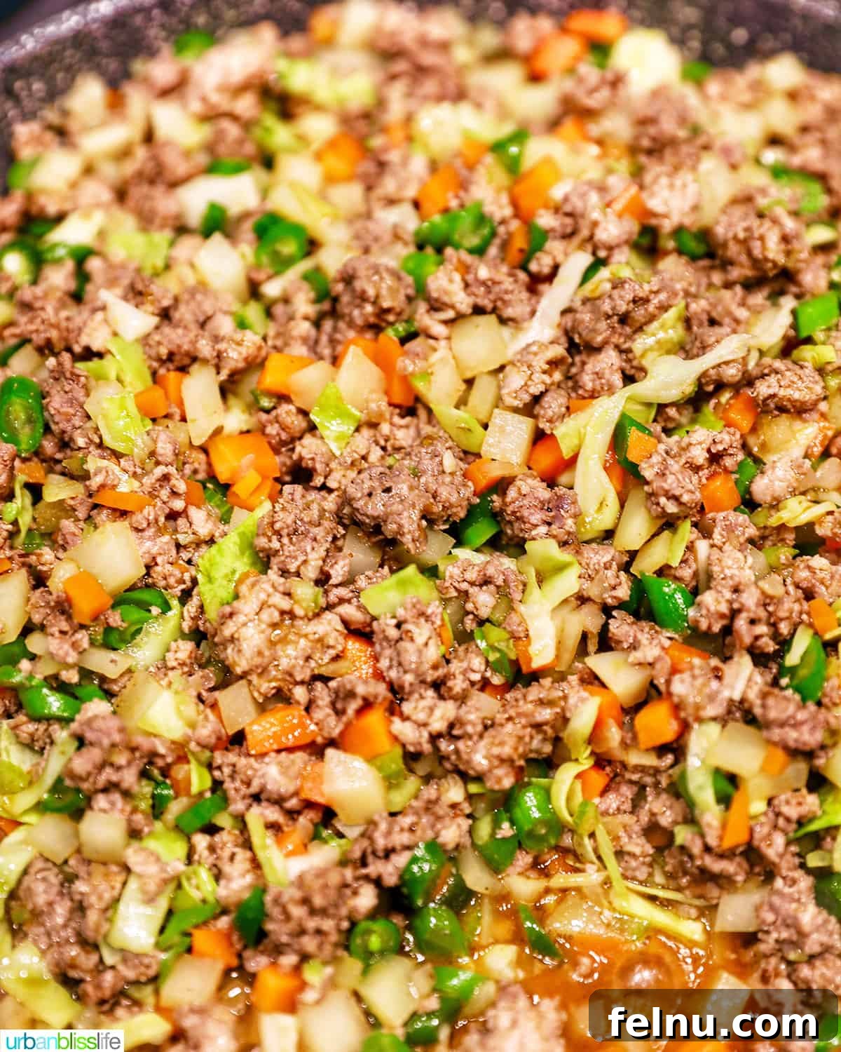 A large pot filled with the cooked and seasoned ground meat and vegetable mixture for Filipino lumpia.