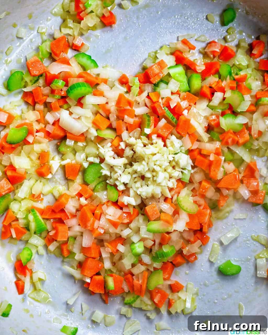 Carrots, onions, and celery cooking in a pan