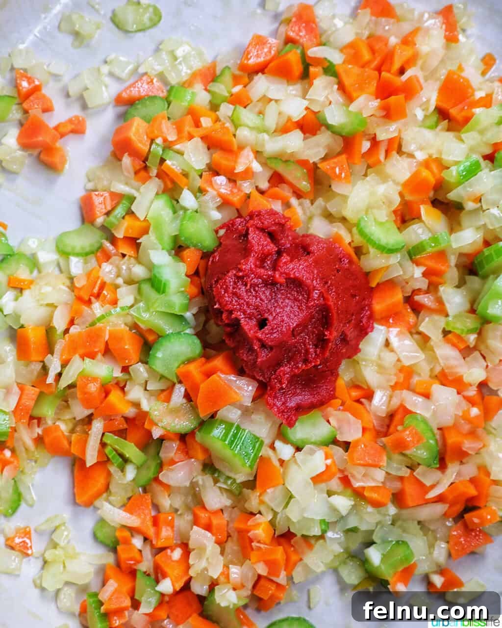 Tomato paste added to carrots, onions, and celery