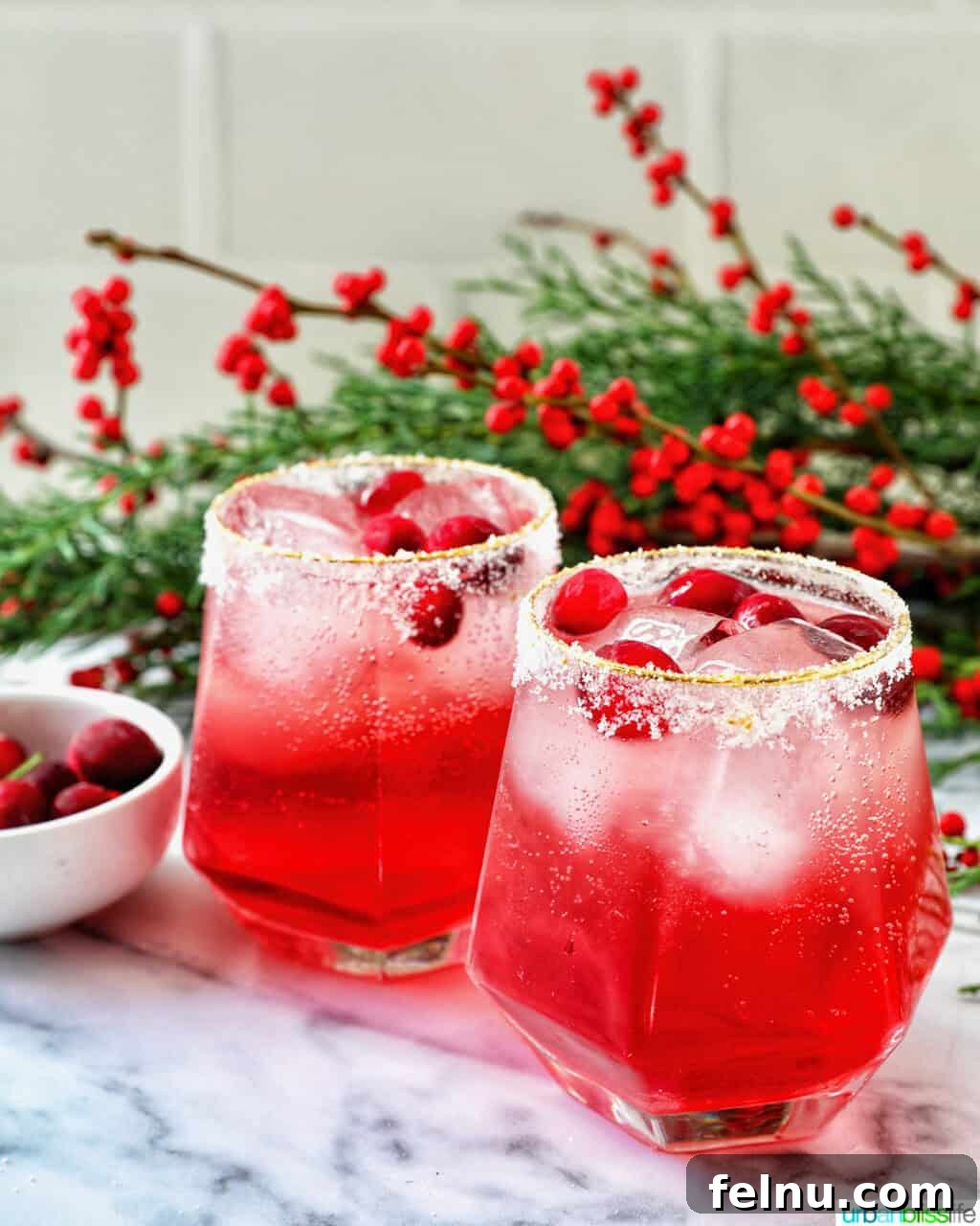 glasses of cranberry mocktail drink with festive christmas decorations.
