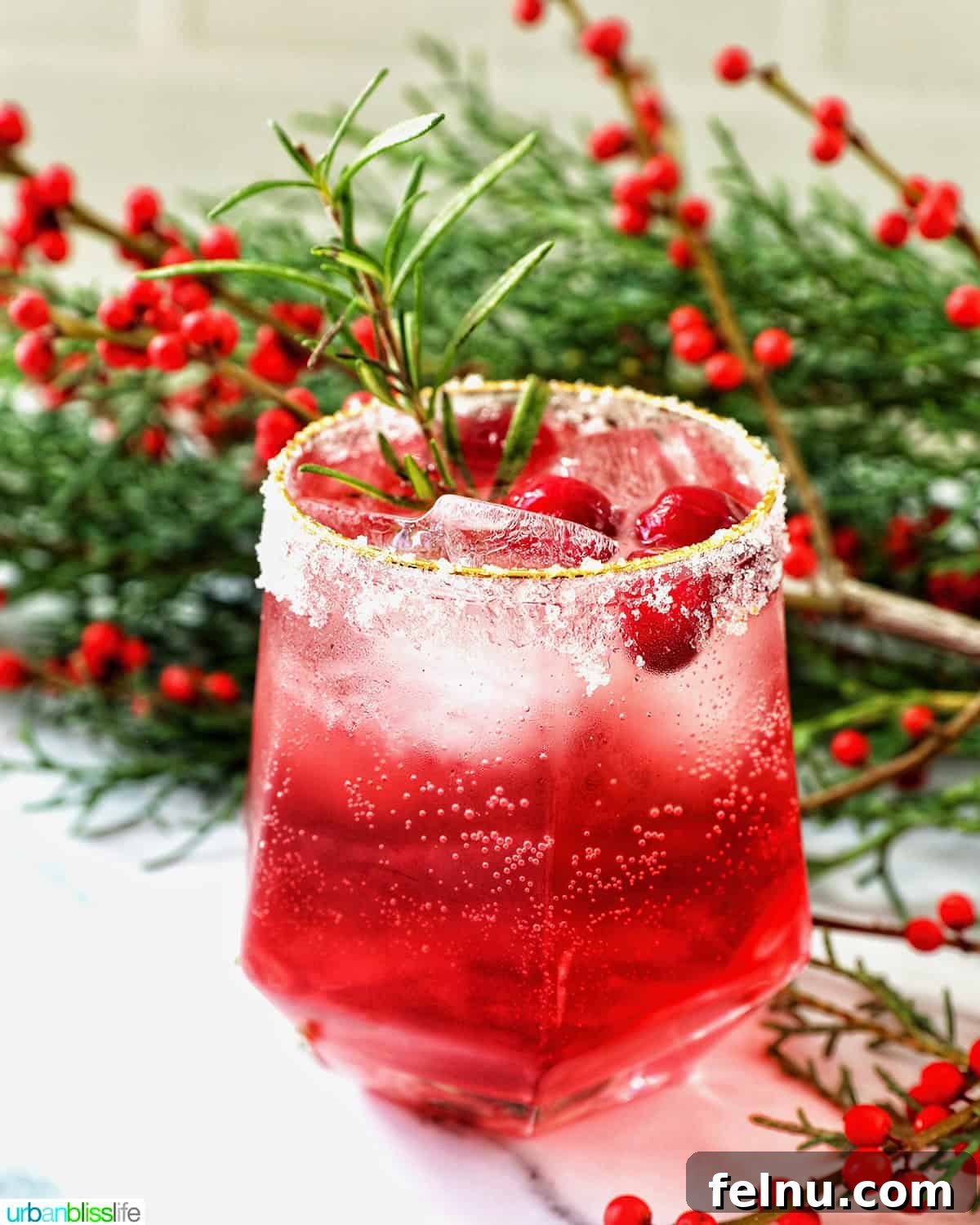 glass of cranberry mocktail drink with festive christmas decorations.