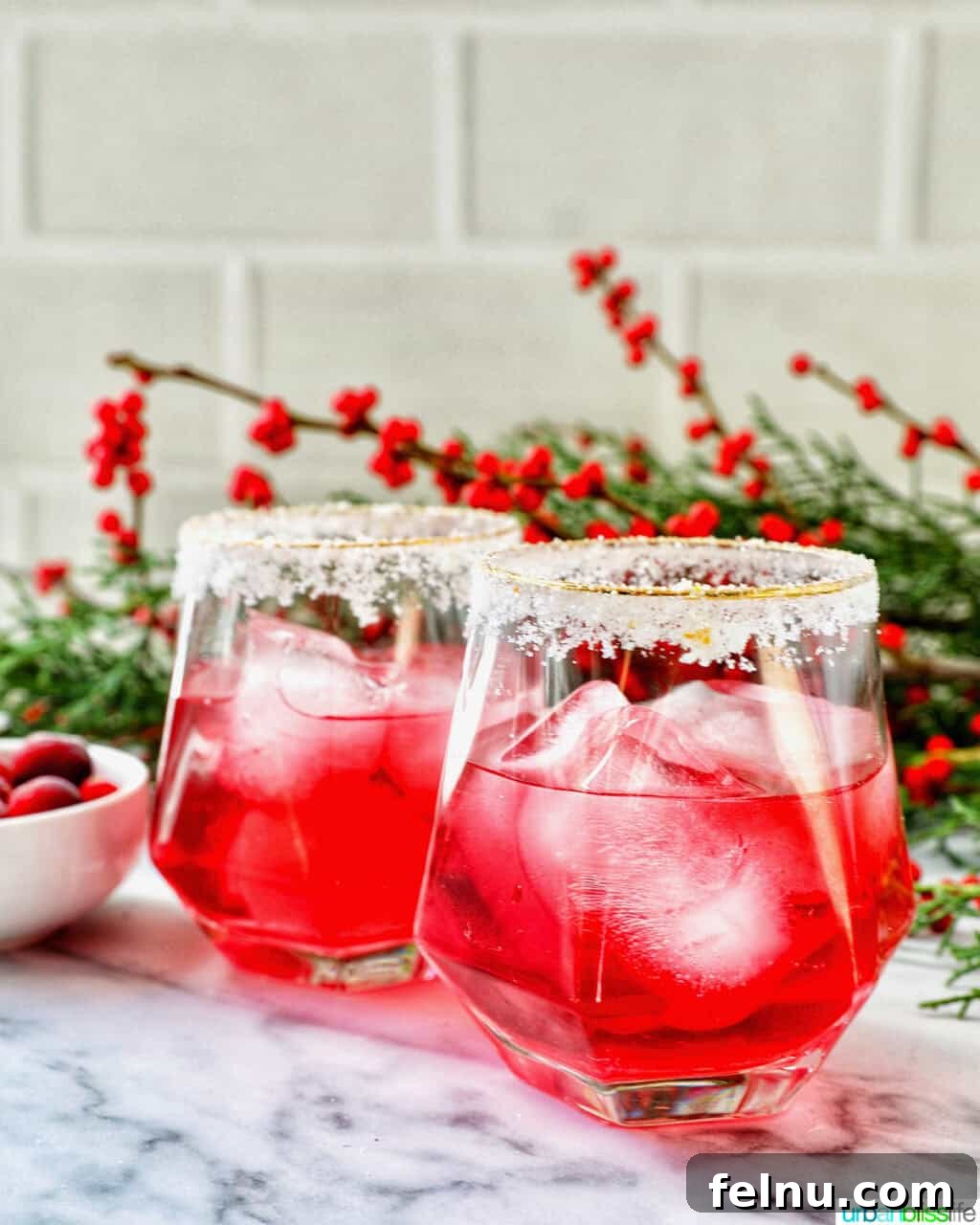 glasses of cranberry mocktail drink with festive christmas decorations.