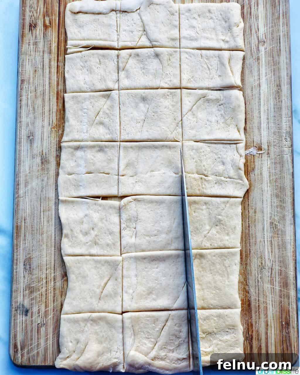 Dough cut into small squares on a cutting board