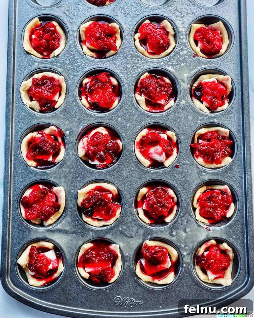 Cranberry brie tartlets in a muffin tin