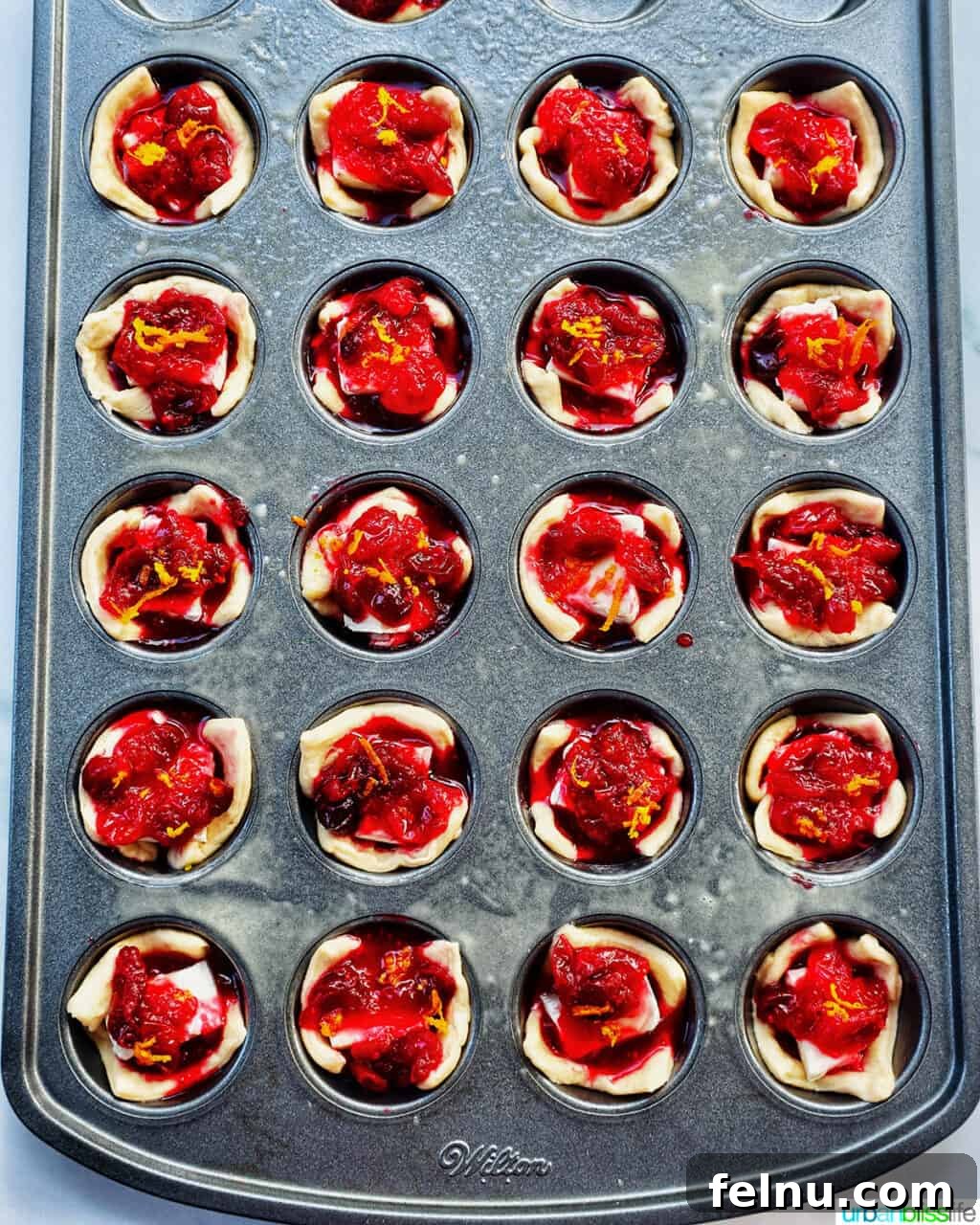 Cranberry brie tartlets in a muffin tin