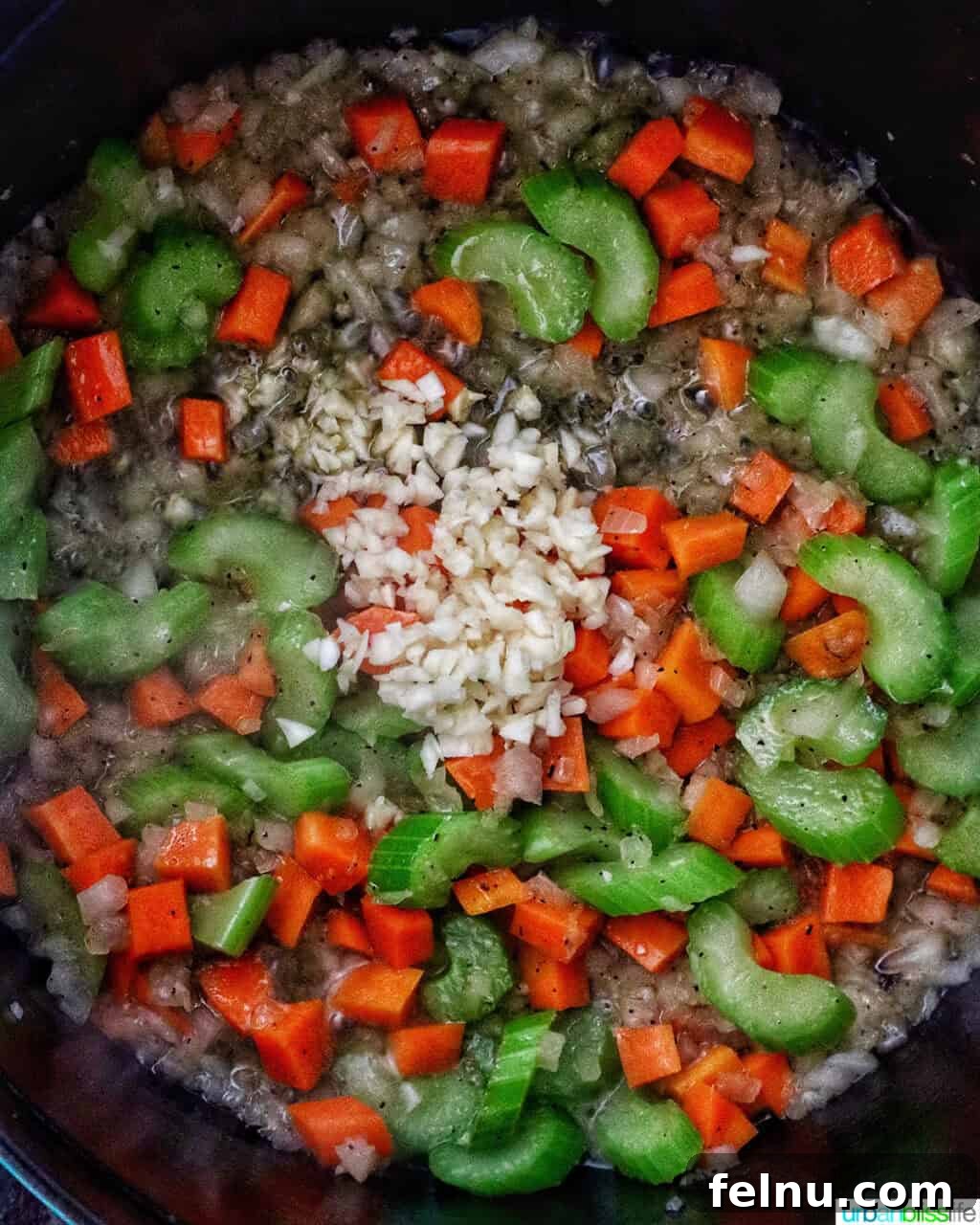garlic added to mirepoix of carrots, celery, and onions in a Dutch oven.